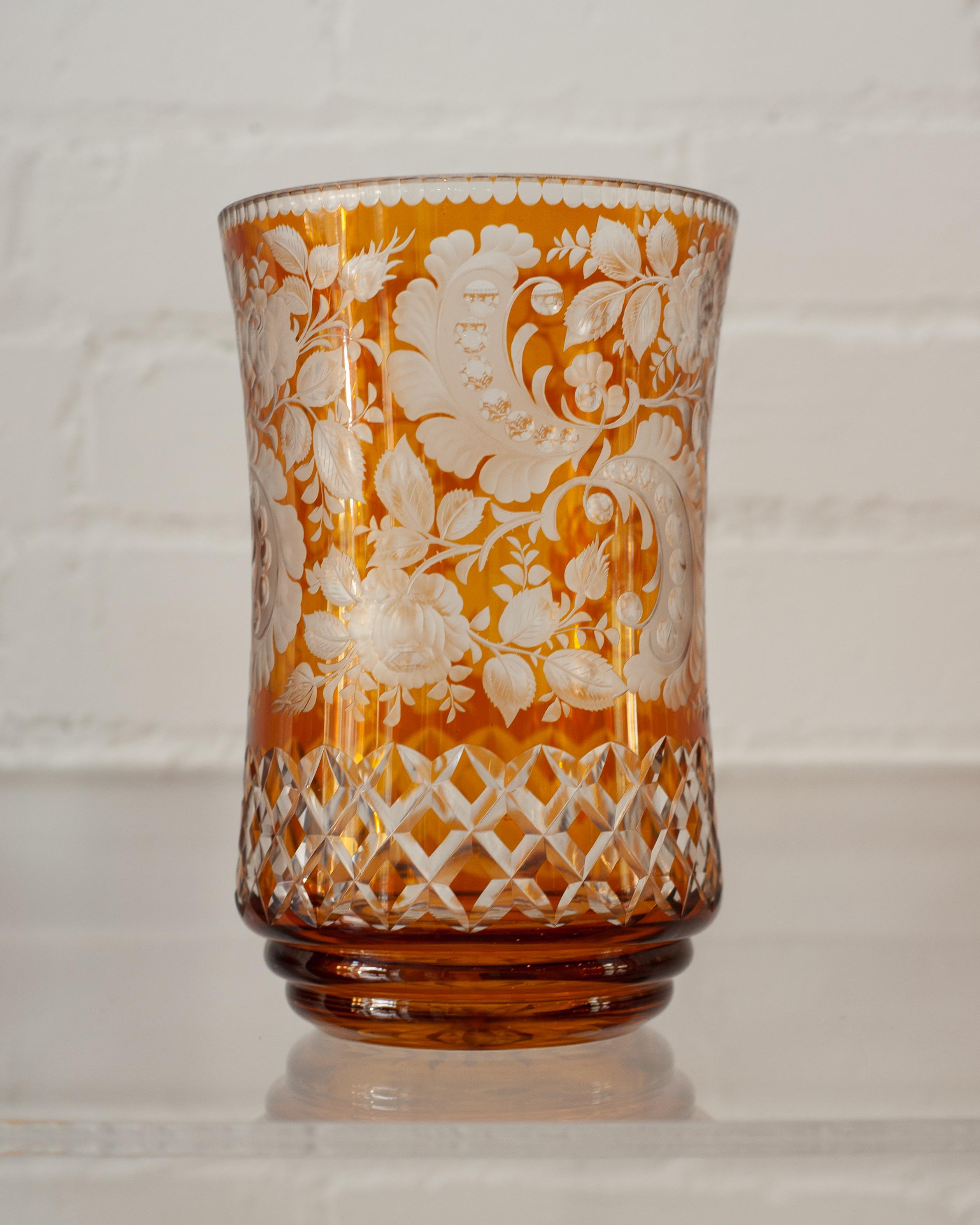 A large Antique Bohemian amber glass vase with cut crystal ornate floral and cross hatch patterns. The artistry of the cut crystal makes this vessel as beautiful as the flowers you may put in them.