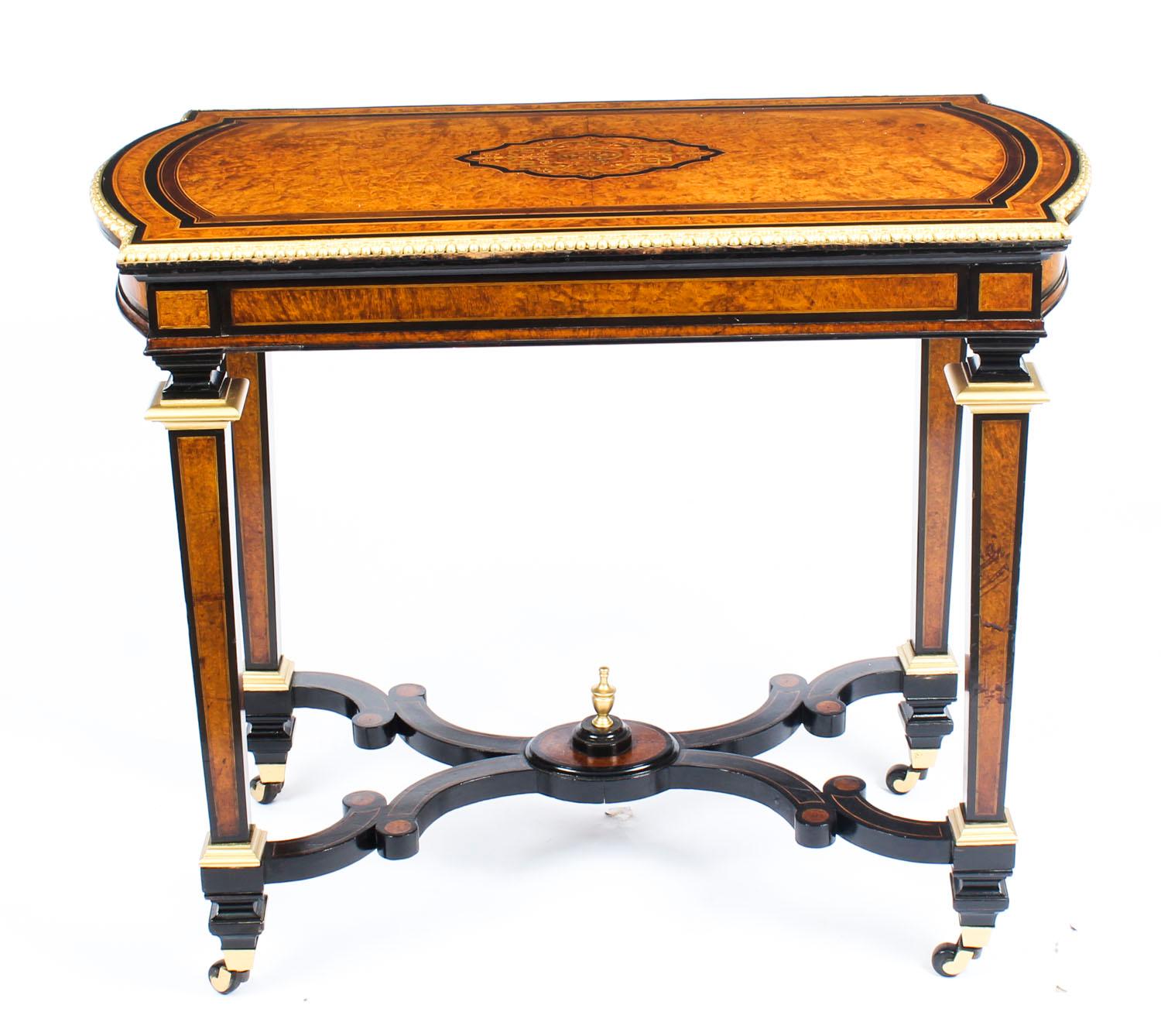 This is a fine antique ormolu mounted Victorian amboyna and ebonized card table, circa 1850 in date.

The shaped inlaid and crossbanded swivel table top enclosing a green baize lining, perfect for playing cards. It is raised on square section