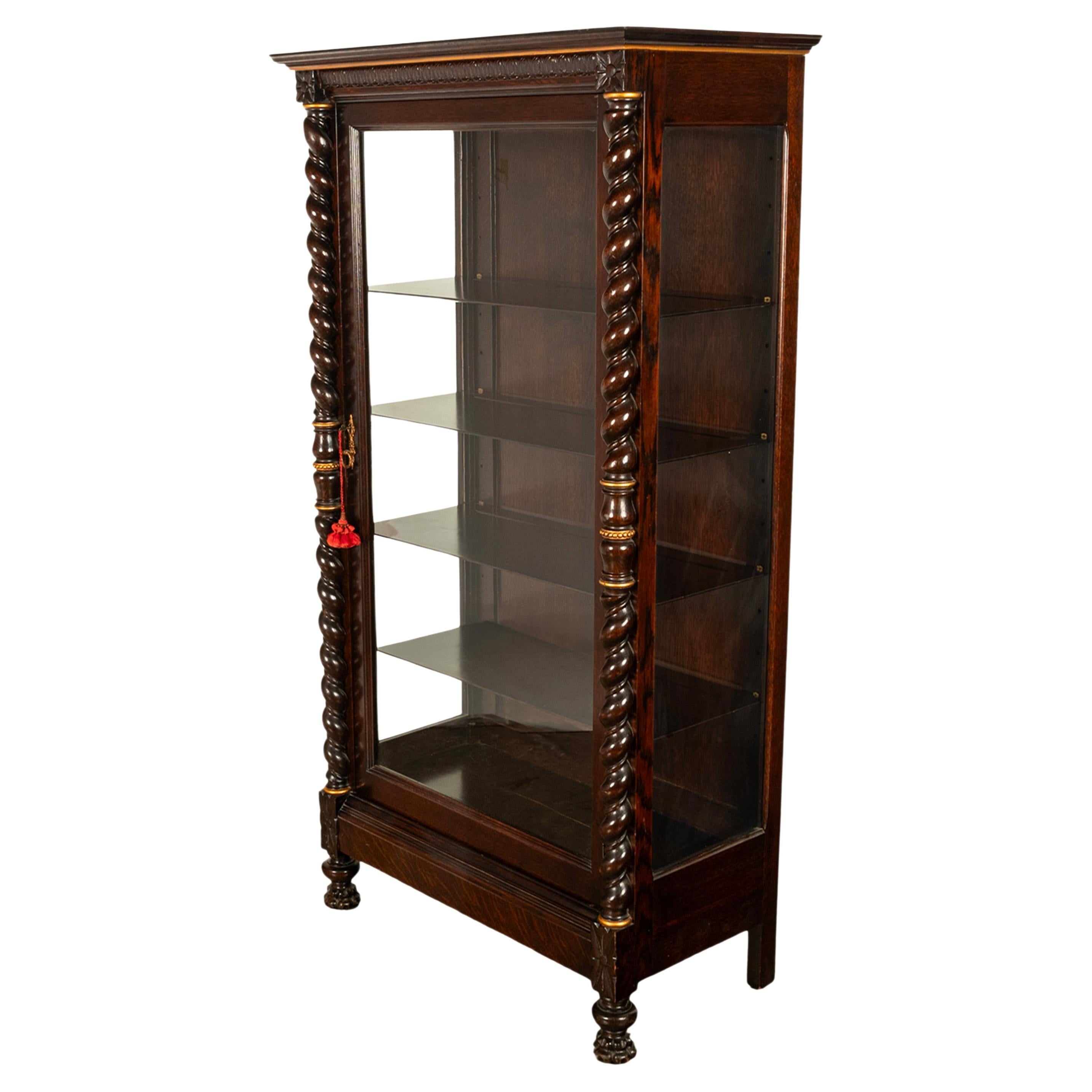 A very high quality antique American quarter sawn oak display cabinet, with 'Barley Twist' Columns, by The Paine Furniture Co., Boston Massachuchetts, circa 1890.
The cabinet with a stepped crown with a gilt border and a ogee shaped egg & dart