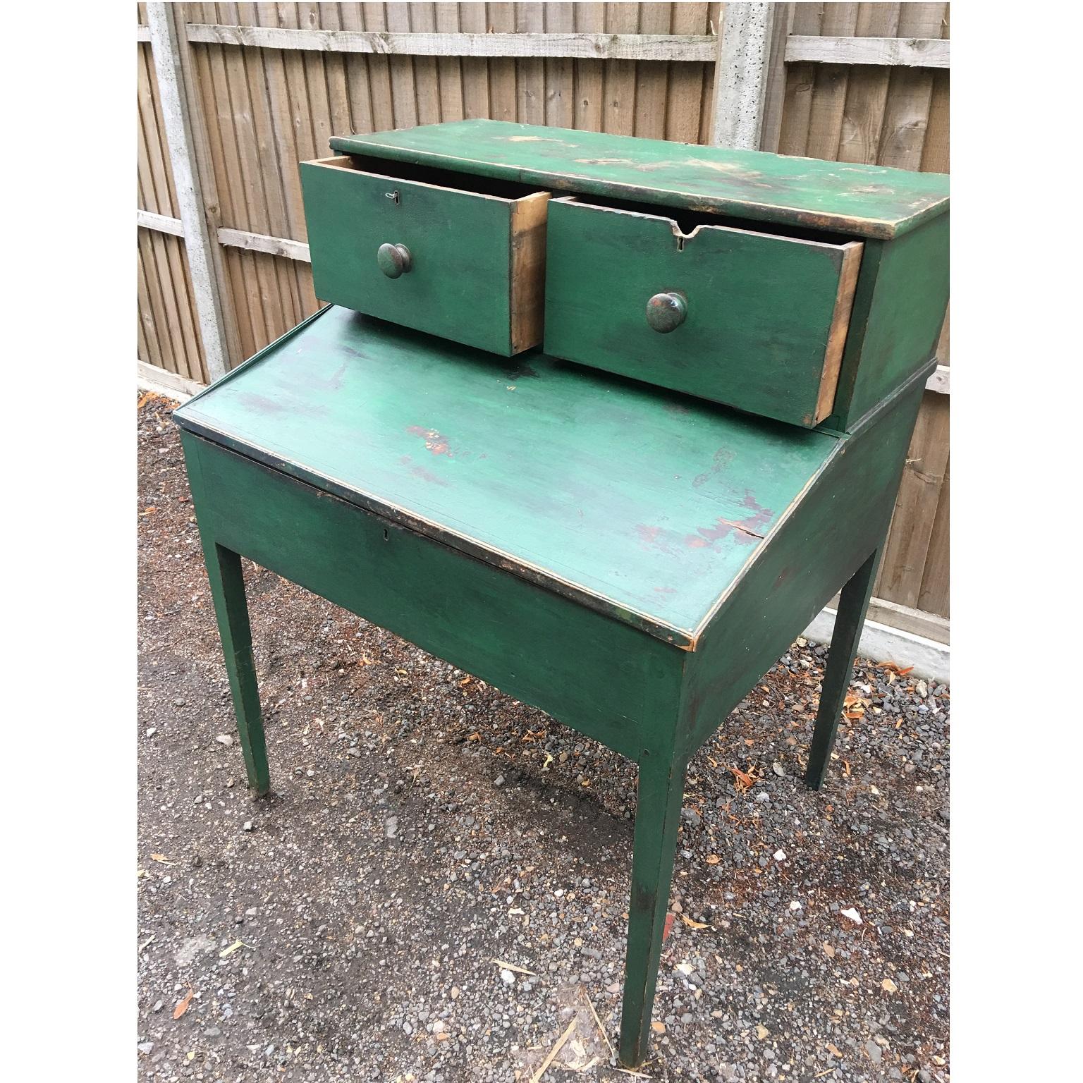 American primitive 19th century green painted clerks desk, possibly a plantation desk,
circa 1880

Standing on four legs, the slope itself has a ledge to hold paperwork and books, it opens to reveal a large compartment with a row of small drawers