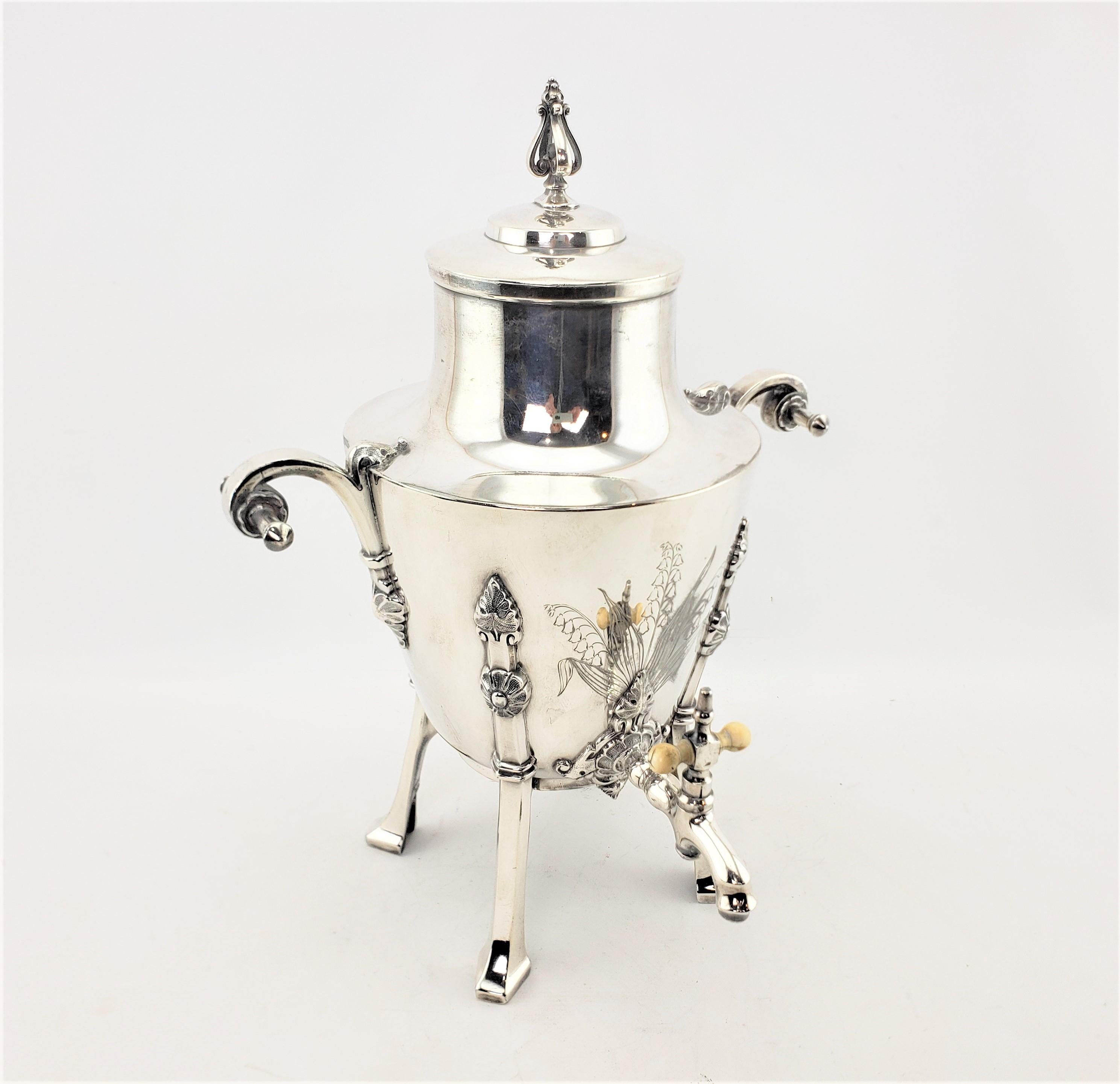 This antique silver plated hot water urn was produced by the well known Simpson, Hall & Miller Co. of the United States in approximately 1900 in the period Aesthetic Movement style. The urn features nicely engraved Lily of the Valley stylized