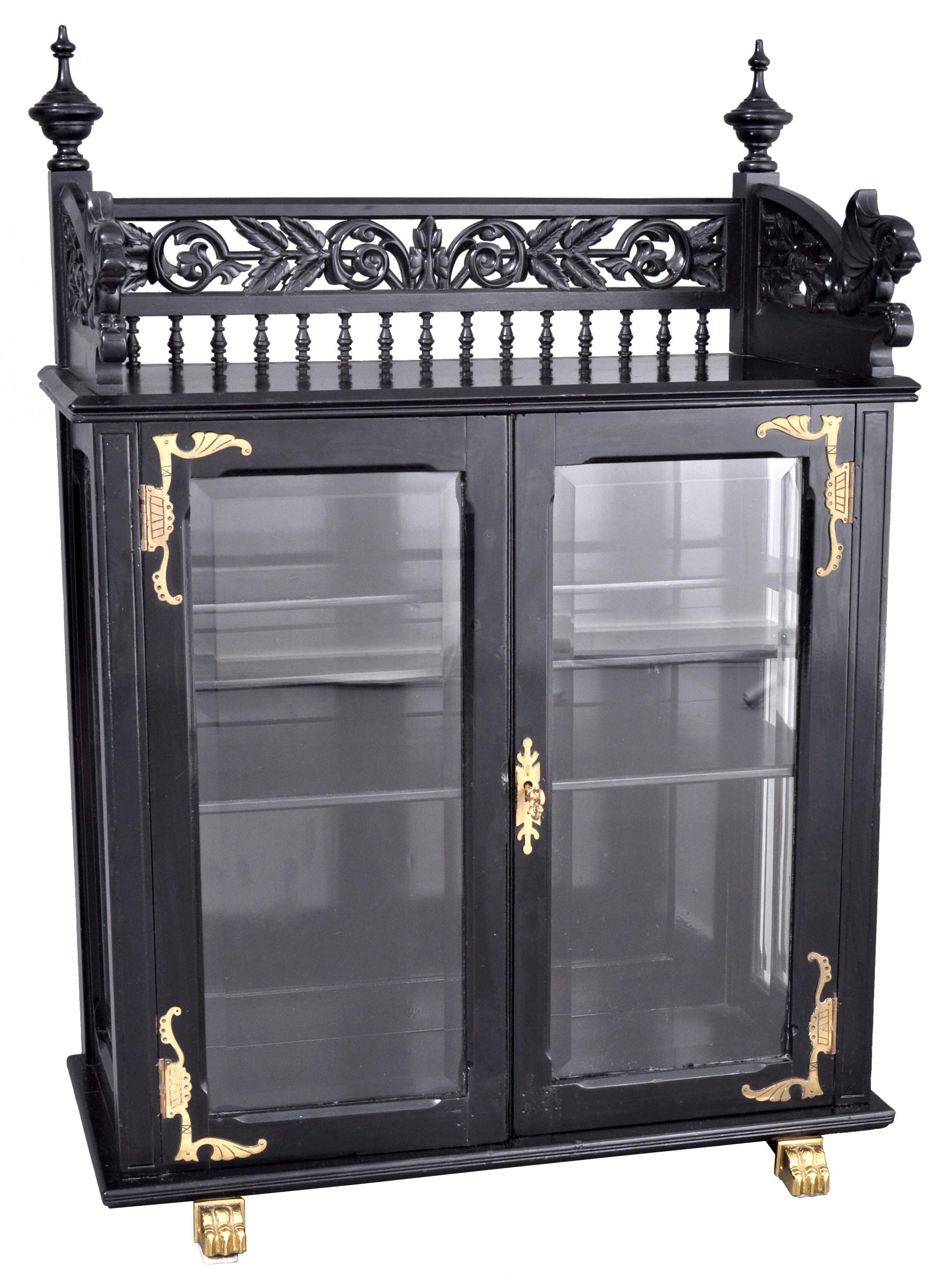 Antique American aesthetic movement carved and lacquered Griffin collector's cabinet, Hutch, circa 1870. The cabinet having an ornately carved and spindled gallery with a pair of tall turned finials and having a pair of resting griffins on each end
