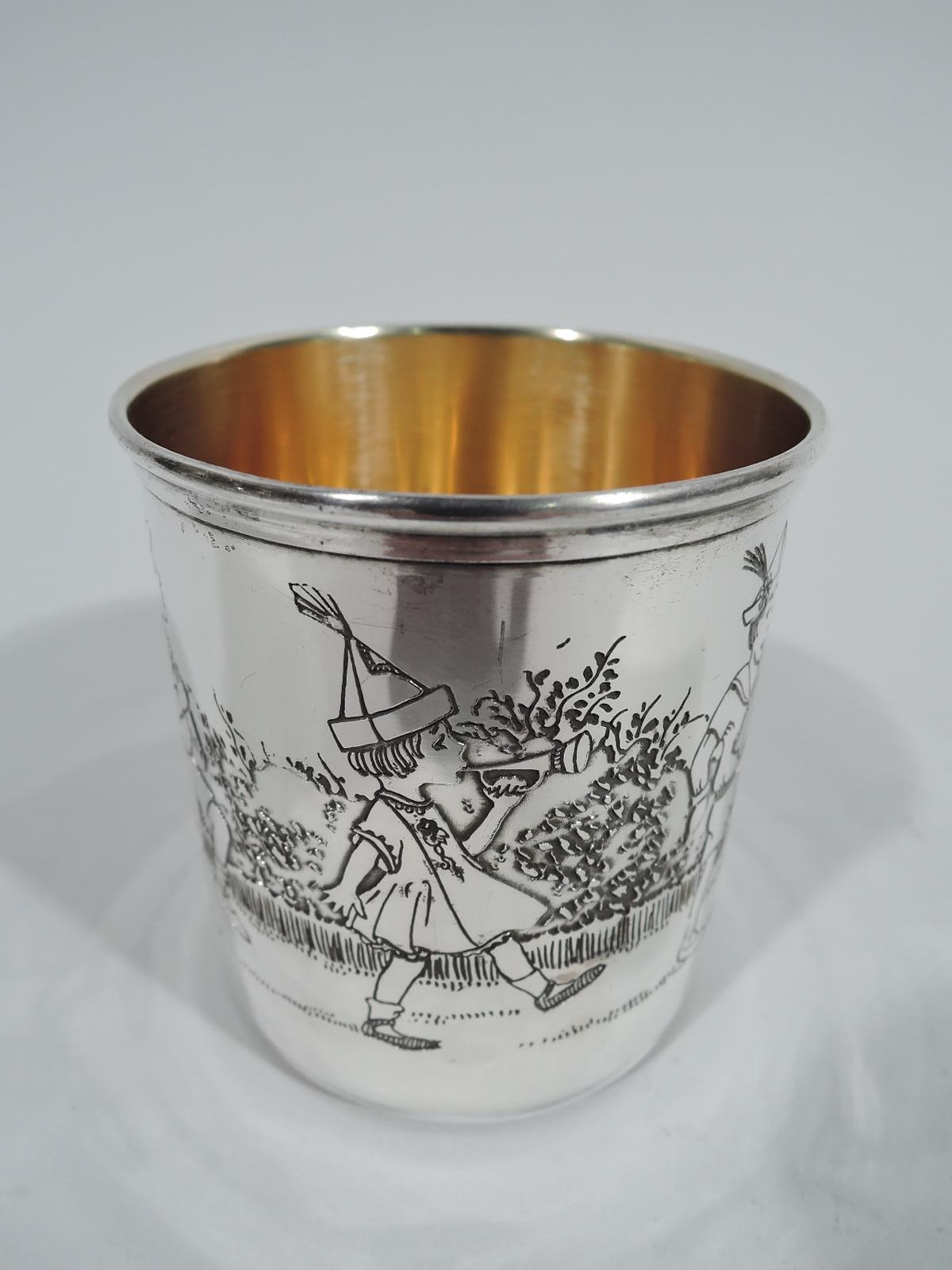 Art Deco sterling silver baby cup. Straight sides, molded rim, and C-scroll handle. Etched procession of boys and girls drumming, trumpeting, sword waving, and flag flying. A sweet piece with patriotic and military undertones. Gilt interior. Fully