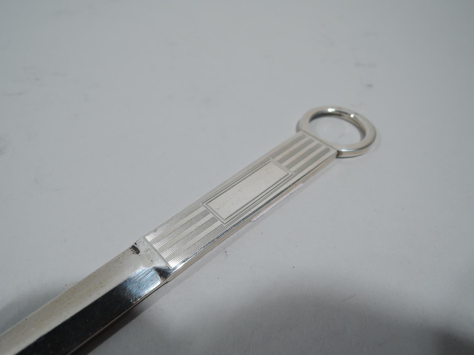 Art Deco sterling silver letter opener. Made by Thomae in Attleboro, Mass., ca 1930. Faceted tapering blade mounted to rectilinear handle with engine-turned lines and rectangular frame (vacant); finger ring terminal. A stylish desk accessory from