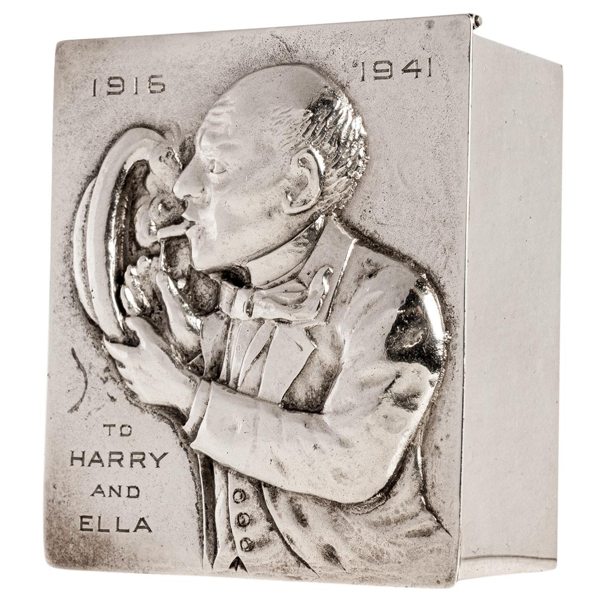 A very good antique American Art Deco repoussé decorated Sterling silver novelty cigarette box, circa 1925.
The hinged lid is deeply decorated with a repoussé work design depicting a dapper dressed gentleman lighting a cigarette, whilst using his