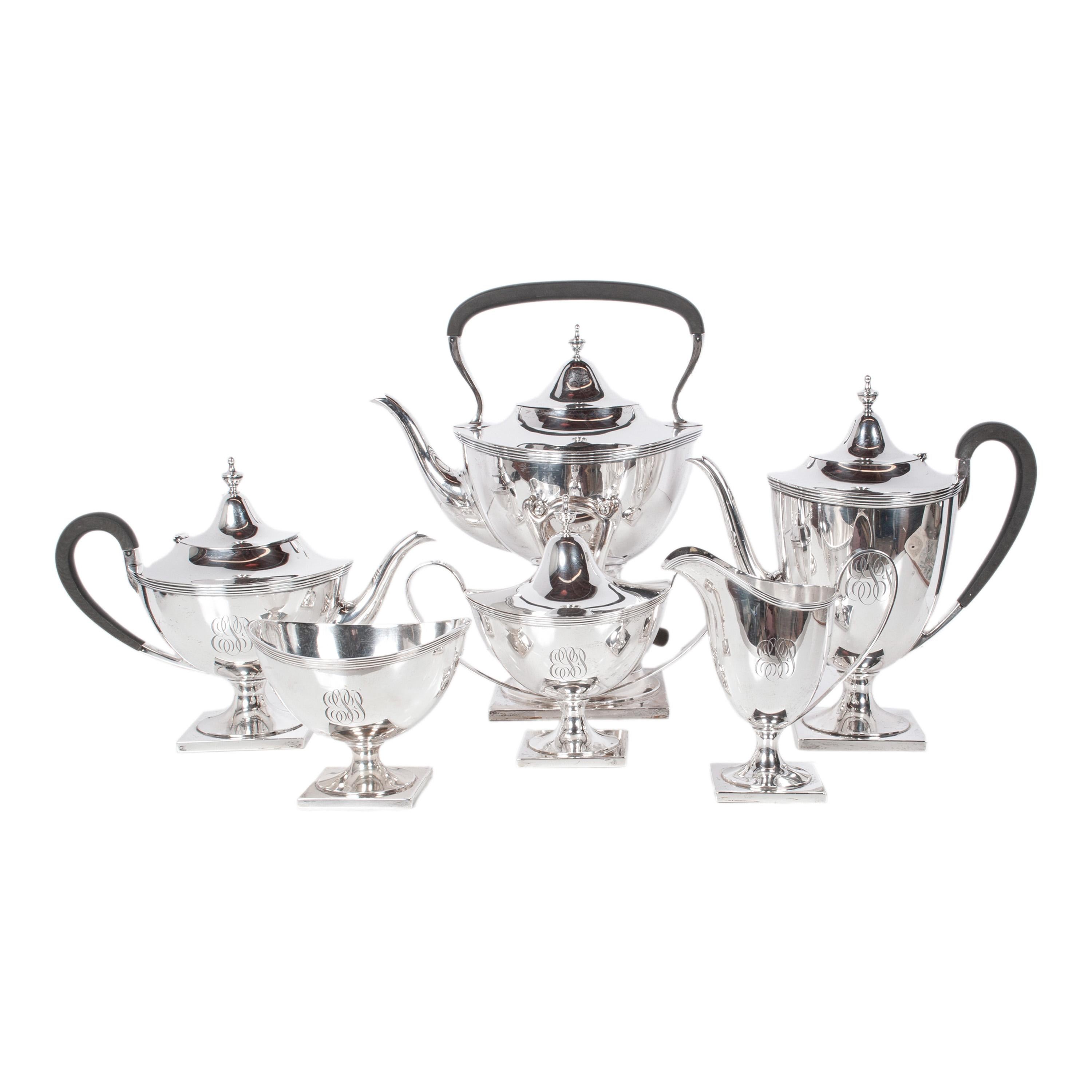 Un antico ed elegante set da tè e caffè in argento sterling Art Deco di 9 pezzi, realizzato da Richard Dimes Co. e venduto al dettaglio da Richard Hodgson Kennard Co., Boston, circa 1925.
Il set comprende un vassoio con piedi e manici, un bollitore