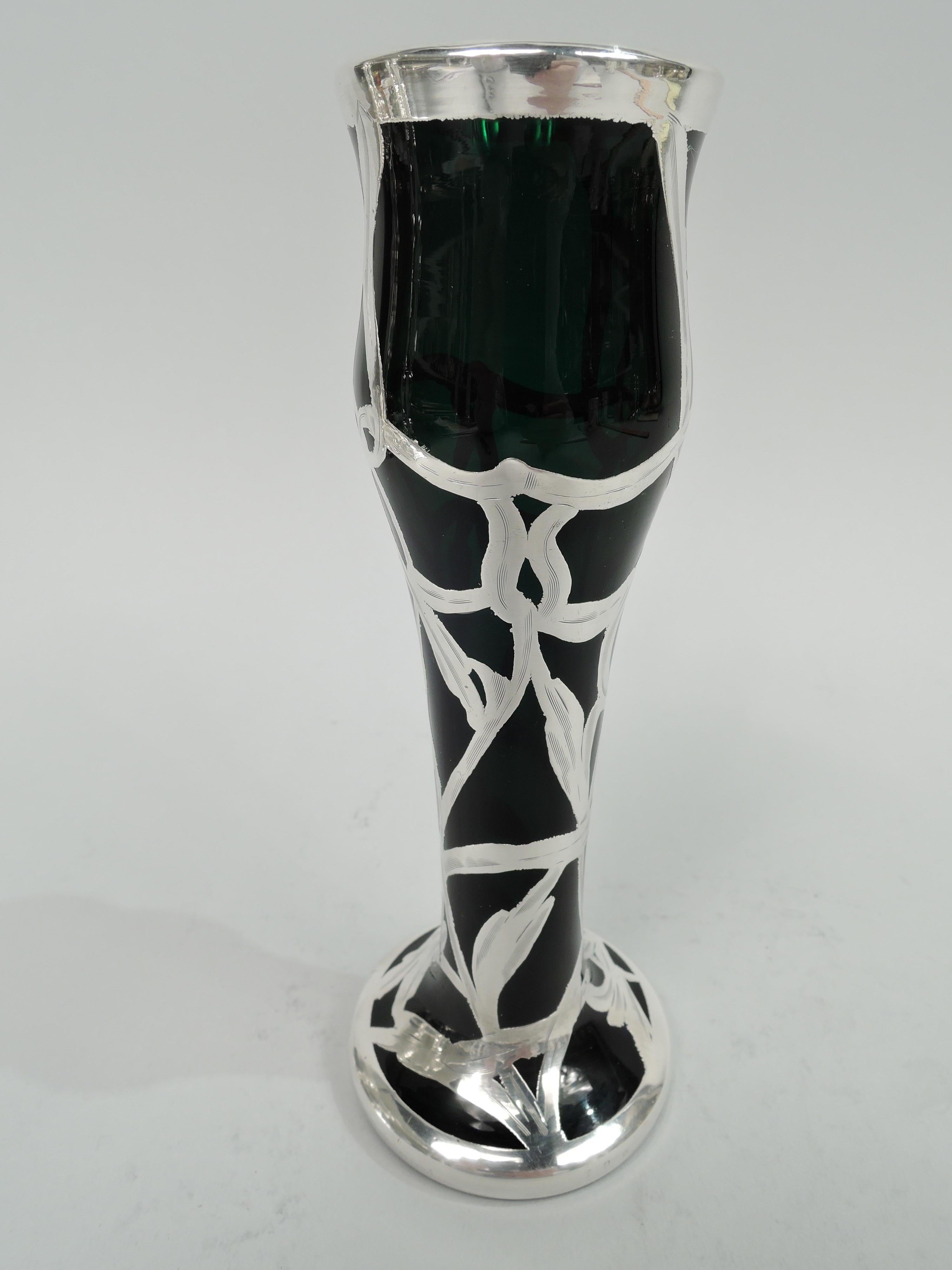 Turn-of-the-century American Art Nouveau glass vase with engraved silver overlay. Tulip-form with flower-bud top on cylindrical body flowing into spread foot. Overlay in form of entwined and interlaced tendrils. Glass is green. Marks include no. 196.