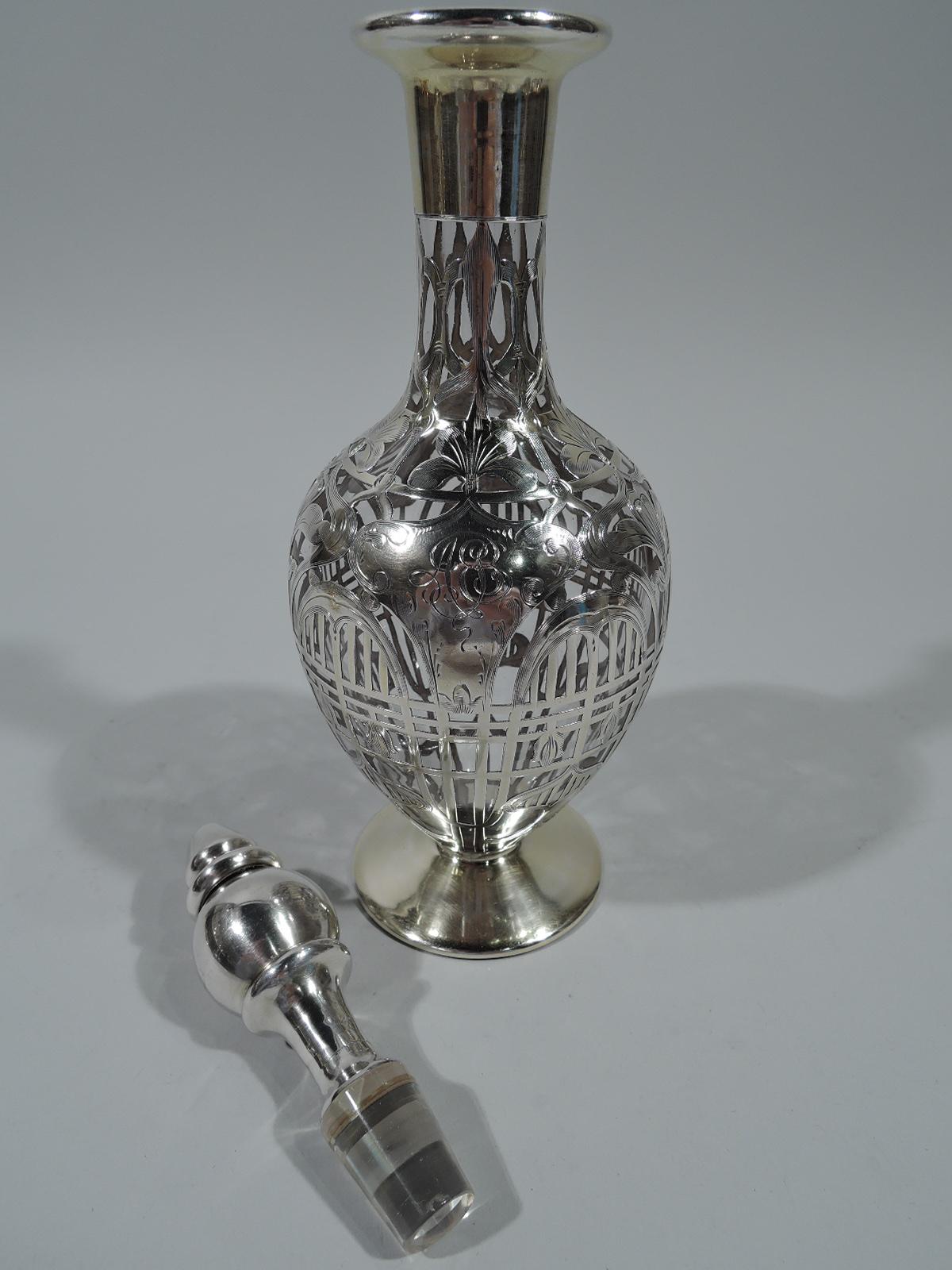Art Nouveau clear glass decanter with silver overlay. Made by Black, Starr & Frost in New York, circa 1920. Oval bowl with flat foot, cylindrical neck, and everted rim. Ball stopper with conical mount, spool neck, and short plug. Dense ornament with