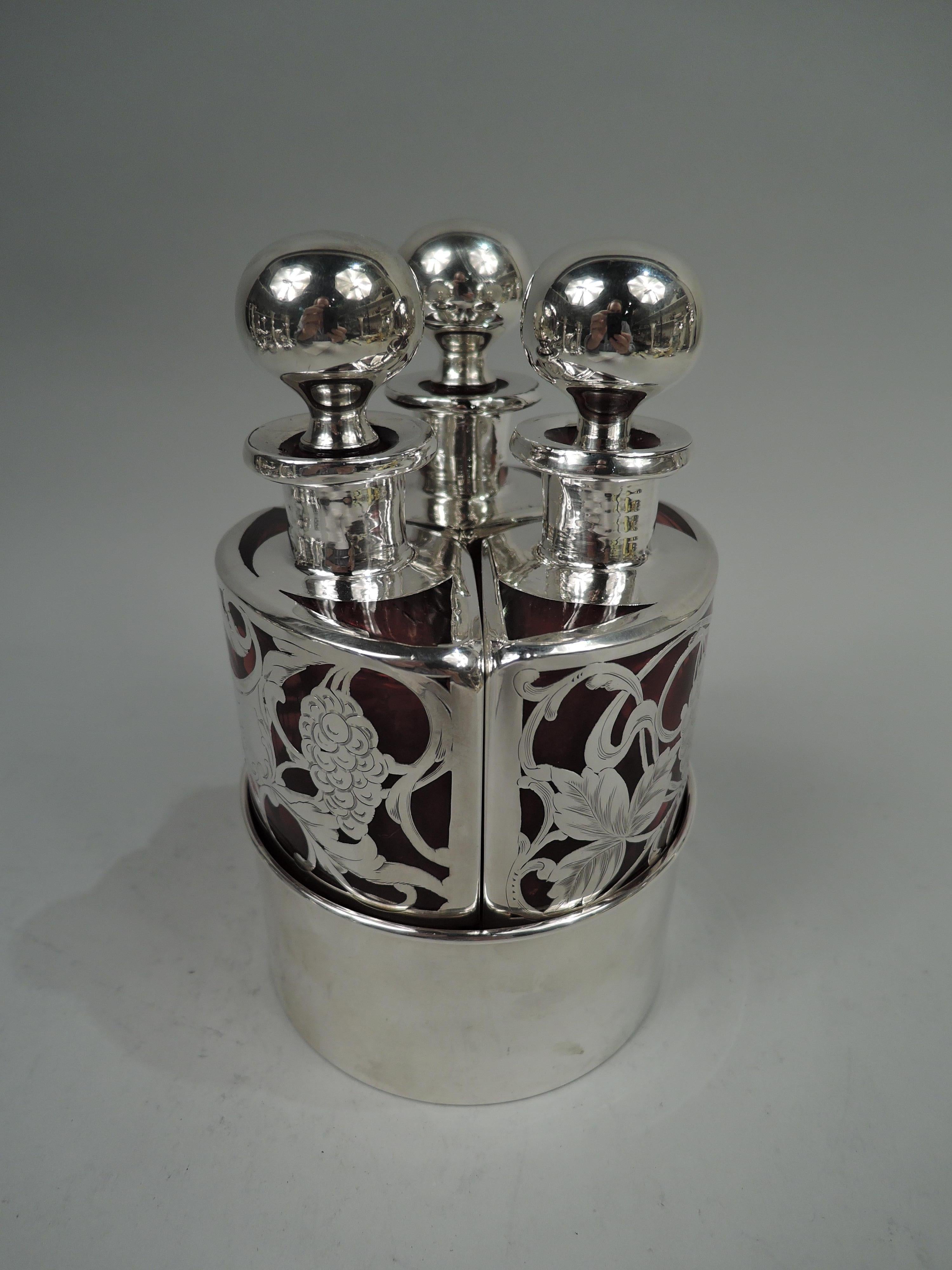 Art Nouveau glass perfume bottle set with engraved silver overlay. Made by Mauser in New York, ca 1900. Three triangular bottles each with curved back in sterling silver ring, forming an elegant geometry lesson. Short neck with everted rim in silver