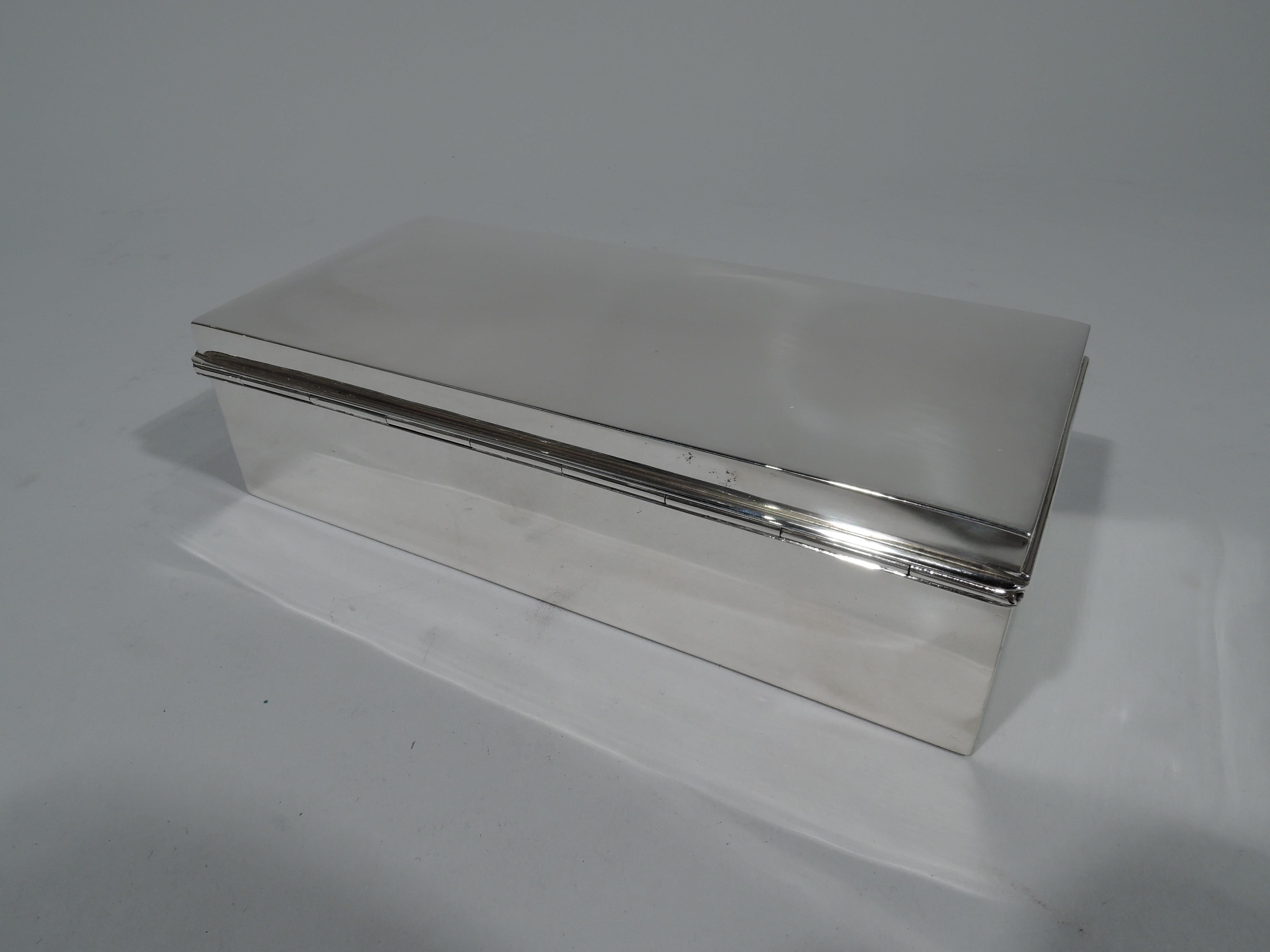 Modern sterling silver box. Made by Tiffany & Co. in New York. Rectangular with straight sides. Cover hinged and gently curved with molded rim. Box interior cedar lined. Cover interior gilt-washed. Hallmark includes pattern no. 18495 (first produced