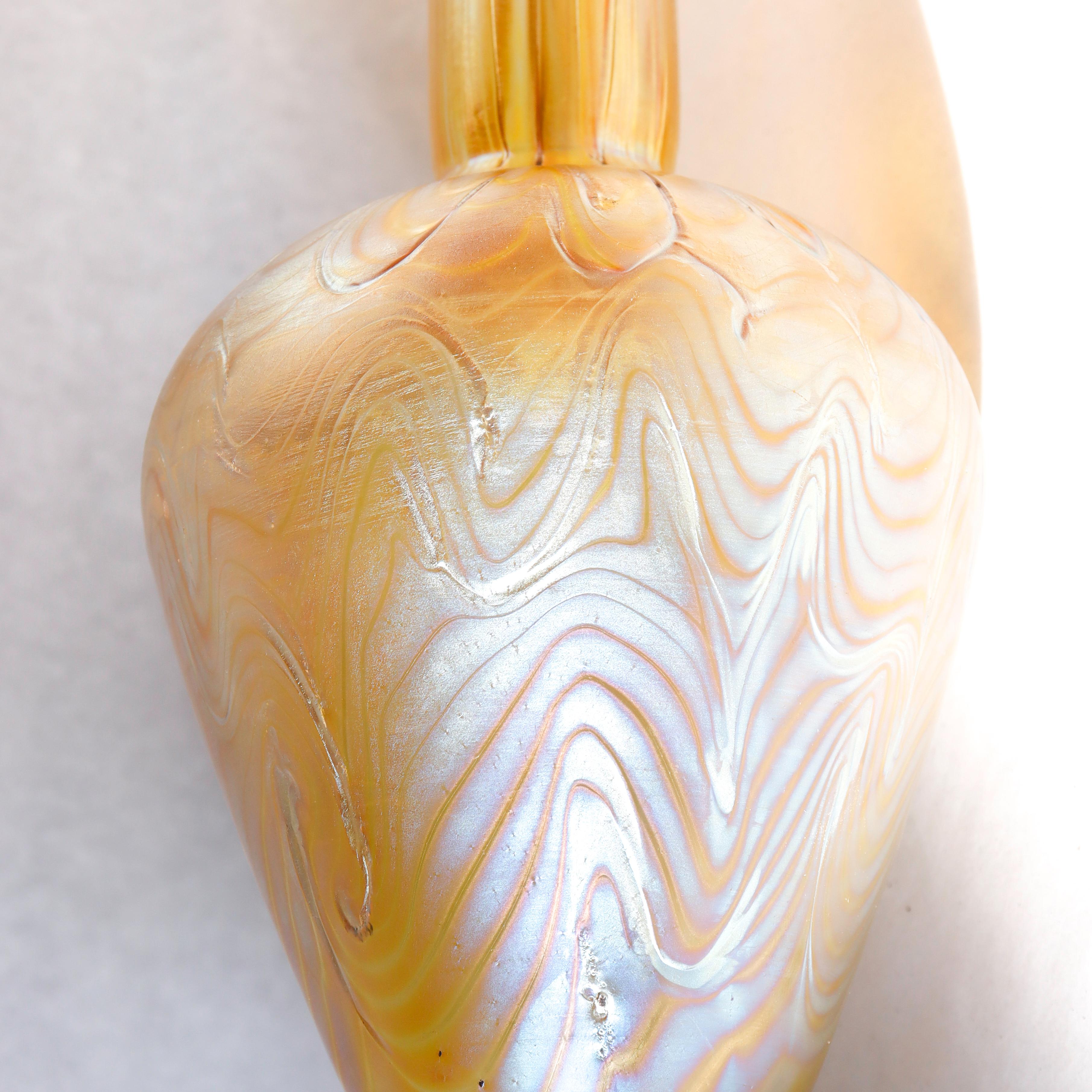 Fino jarrón Art Nouveau de vidrio artístico montado en plata.

Consta de un cuerpo de vidrio Loetz Phaenomen en coloración Candia y una montura de plata tipo Martel de estilo Art Nouveau martillada a mano por la Hartford Sterling Company de