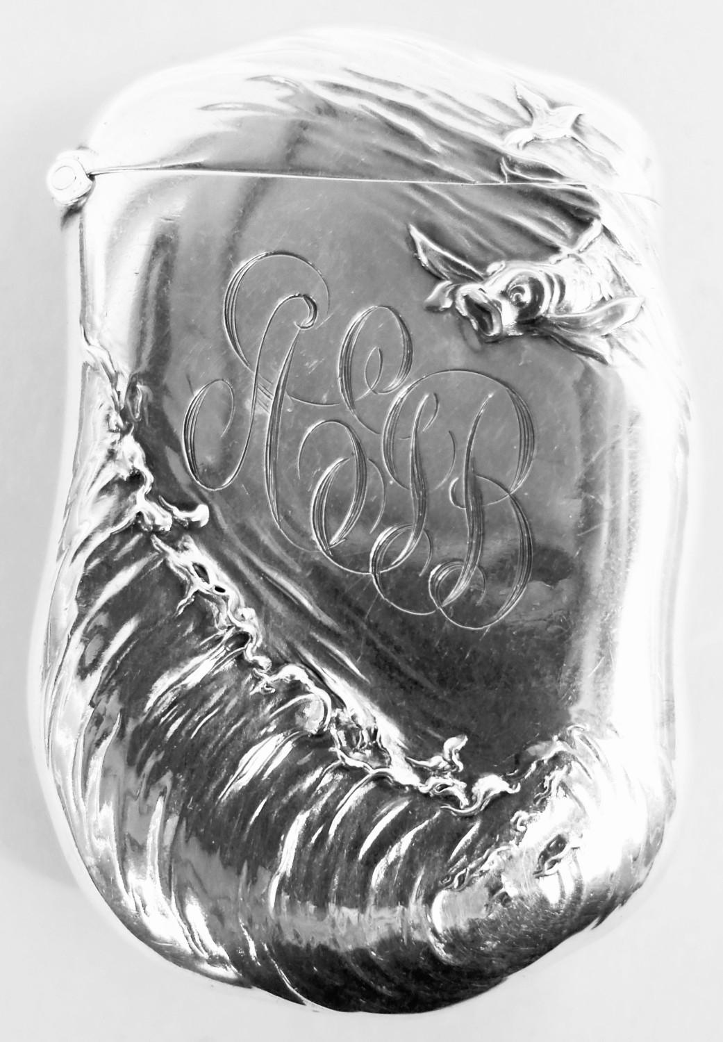 Art Nouveau sterling silver match safe. Made by William B. Kerr in Newark, ca 1890. Shaped with hinged cover and strike. On front in relief the Lorelei rise out of roiling water with beckoning arms. On back, engraved interlaced script monogram.
