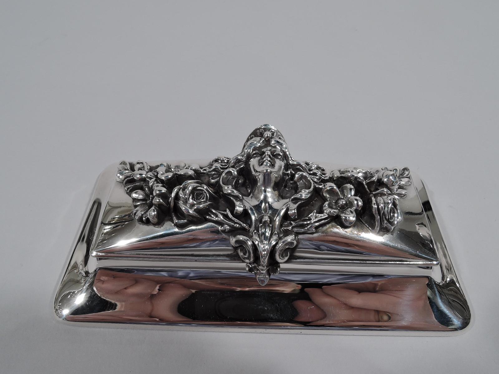 Art Nouveau sterling silver postage stamp box. Made by William B. Kerr in Newark, circa 1900. Rectangular on spread base. Cover hinged and raised with applied floral garland, a female head at center. A splendid and tactile take on the
