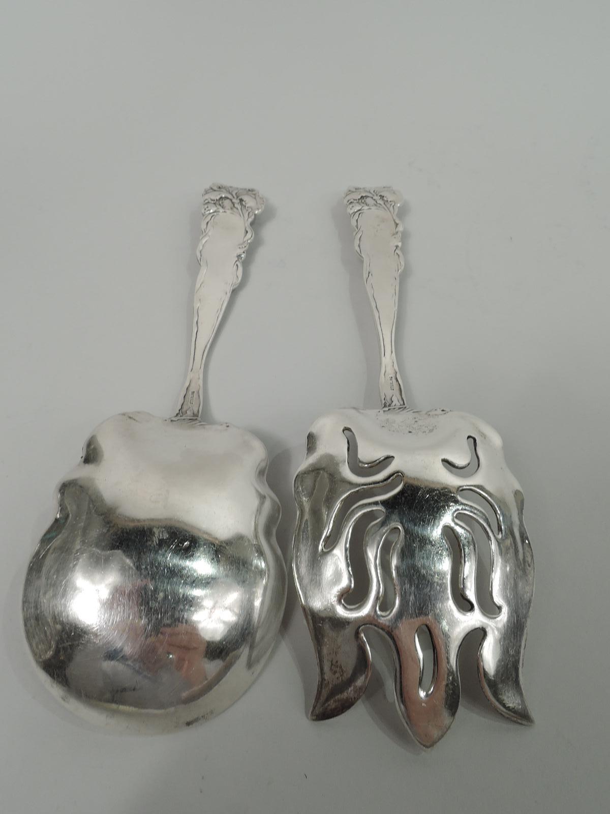Pair of turn-of-the-century American Art Nouveau serving pair. Shaped bowl. Shank same with 3 tines and ornamental piercing. Floral mount and handle with drapery-clad bacchante holding aloft tendrils. A risqué design for the salad course. Marked