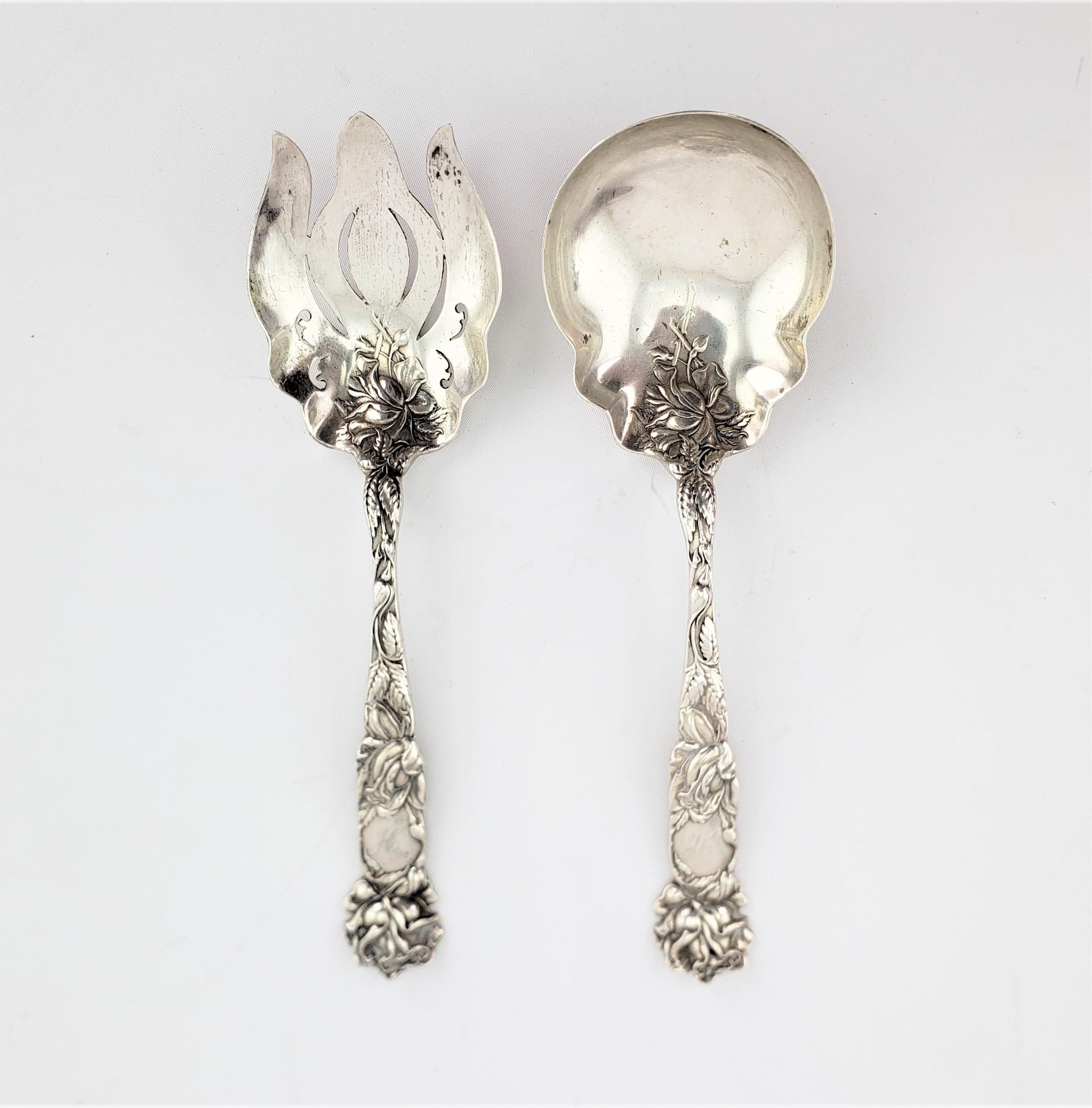 This set of antique sterling silver serving spoons are unsigned, but presumed to have been made in the United States in approximately 1890 in the period Art Nouveau style. The handles are decorated with flowers and leaves done in high relief which