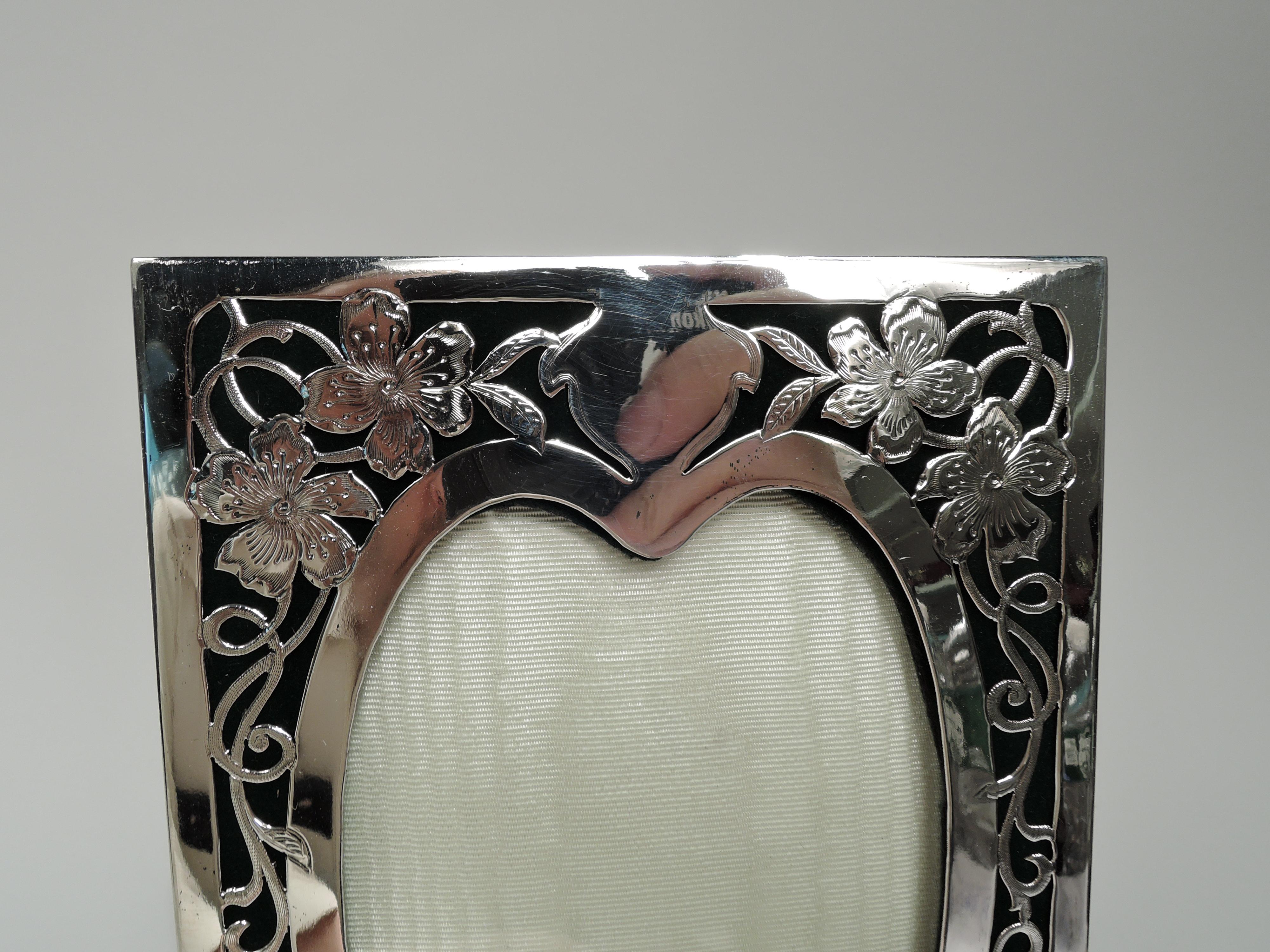 Art Nouveau sterling silver picture frame. Heart-shaped window surrounded by open flowing tendrils on green velvet ground. At top solid shaped cartouche (vacant). Surround rectangular. With glass, silk lining, and velvet back and hinged easel