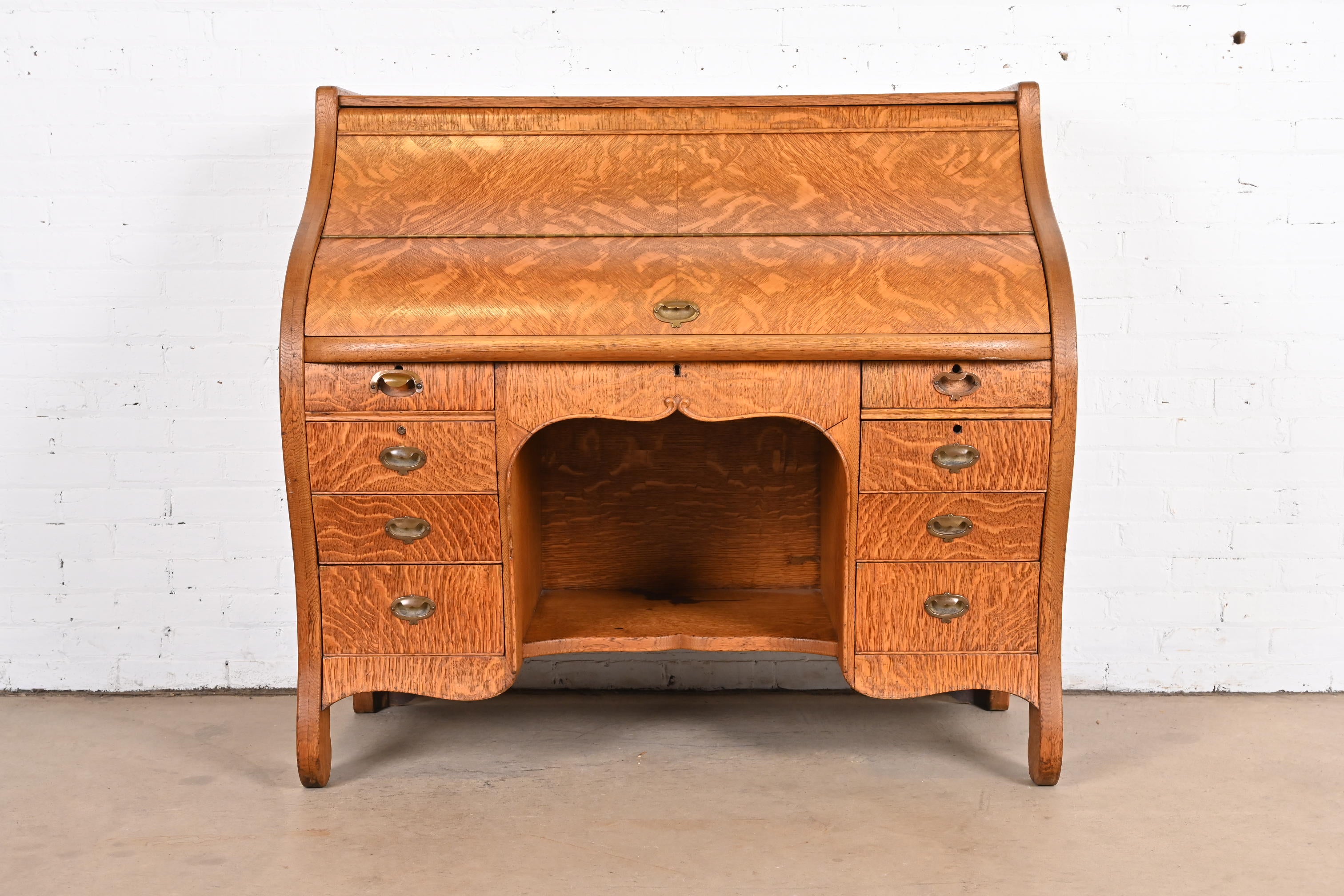 An exceptional antique Arts & Crafts desk with unique folding roll top

USA, Circa 1890s

Beautiful quarter sawn oak, with birdseye maple drawer interiors and brass hardware.

Measures: 48