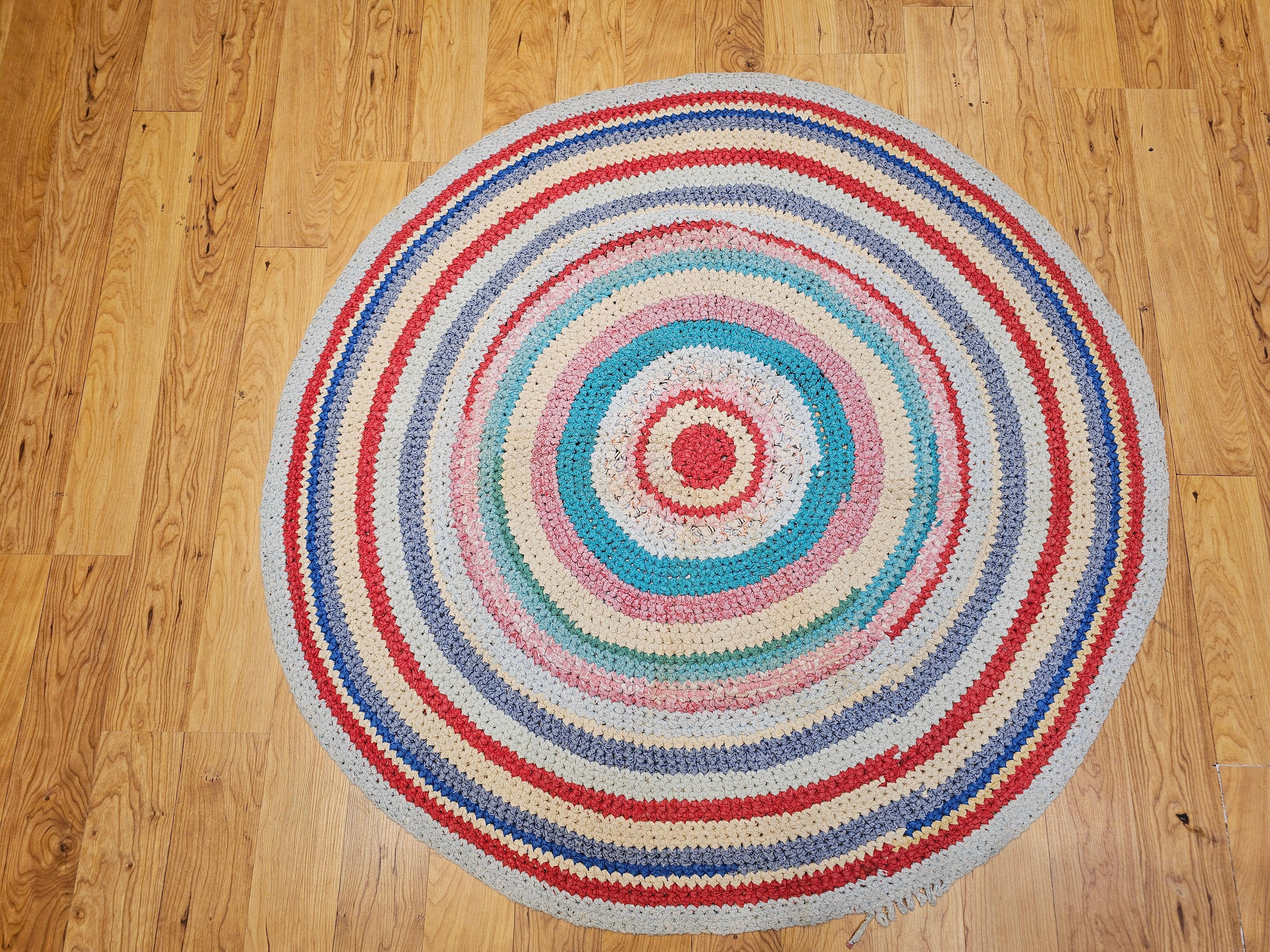 Antique American Braided Round area rug in blue, red, ivory, green from the 2nd quarter of the 1900s in Red, White, Blue, Yellow, Gray colors.  The rug design and colors are very lively and have a special beauty and vibrancy.  The rug is a best