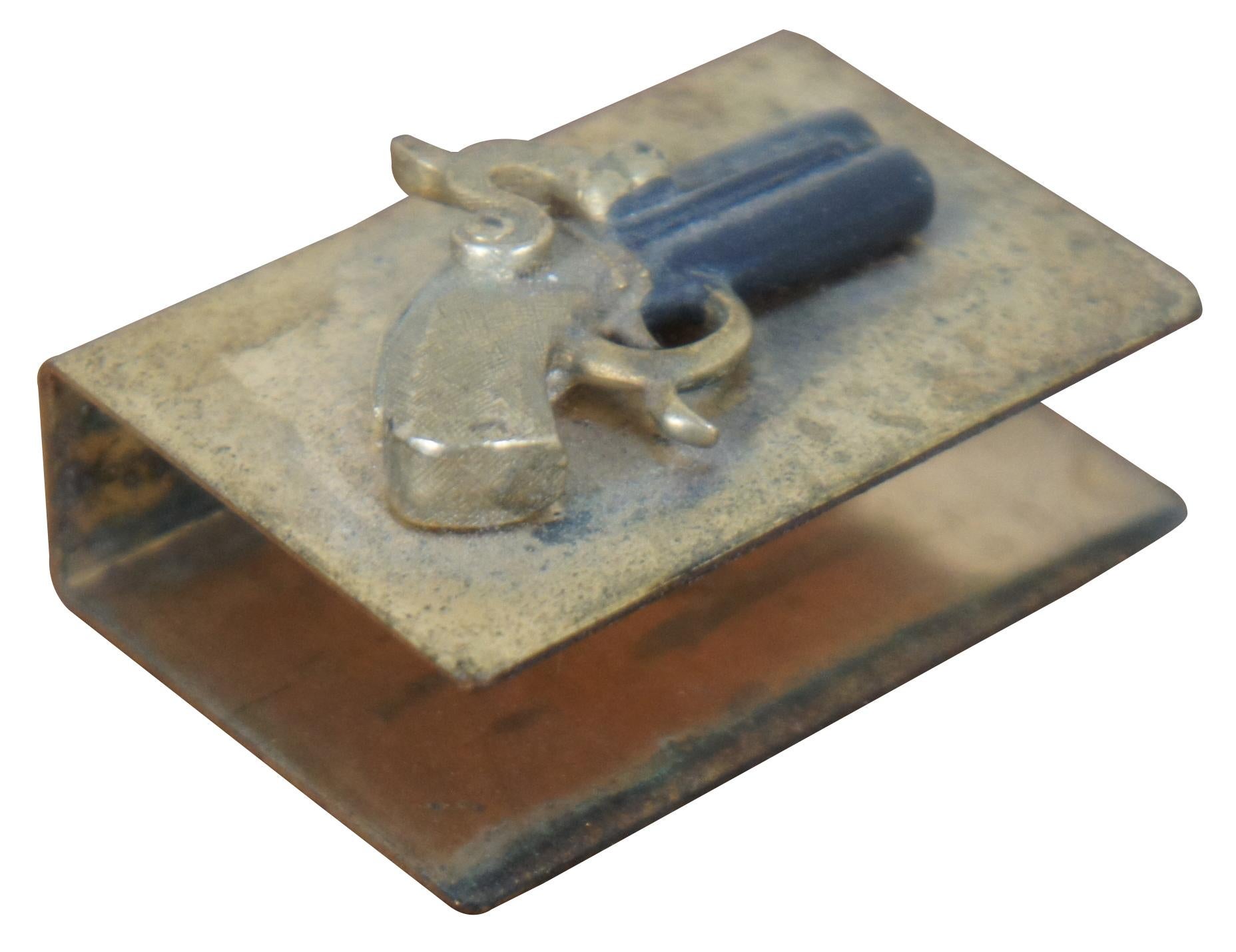 Antique brass pocket sized matchbox holder decorated with a three dimensional flintlock pistol.
 