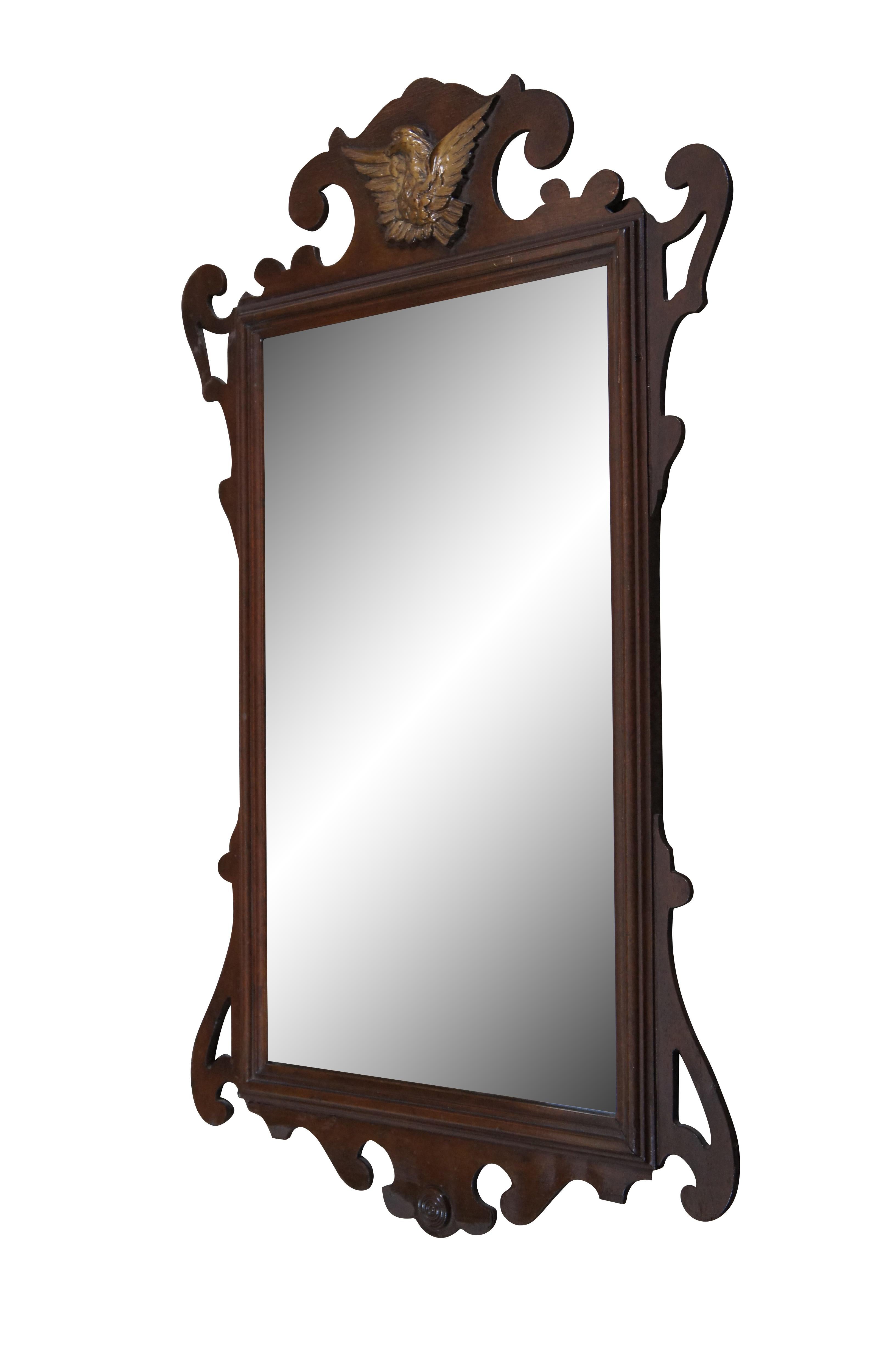 Vintage American Chippendale / Federal style wall / vanity mirror featuring a carved mahogany frame with pierced serpentine form and golden Eagle crest.

Dimensions:
19