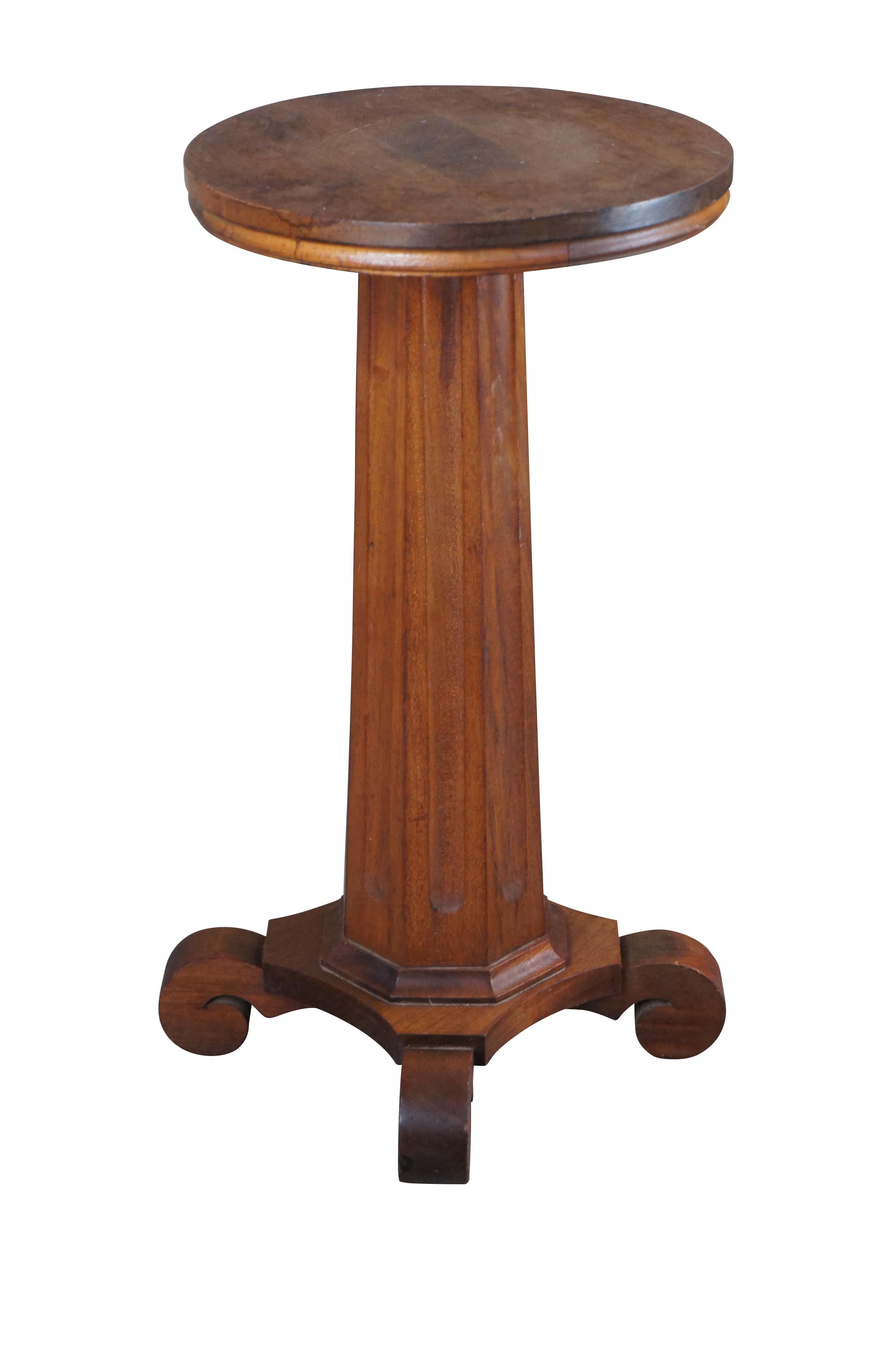 An antique 19th century American Classical / Empire pedestal table or sculpture / candle stand. Made from solid mahogany with a round top over fluted octagonal column graduating towards a 