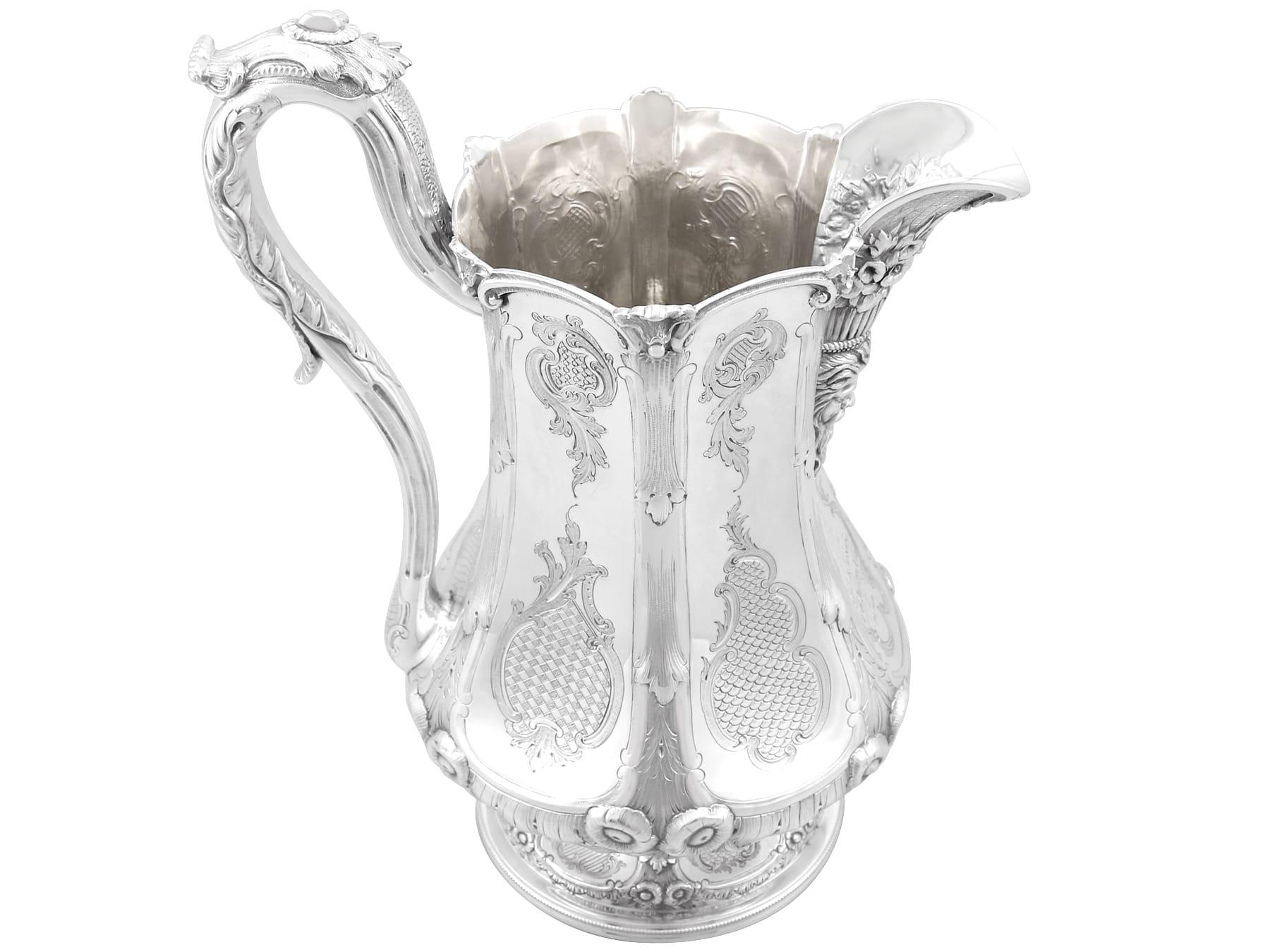 An exceptional, fine and impressive, large antique American coin silver water pitcher; part of our dining silverware collection.

This exceptional antique coin silver water pitcher has a baluster shaped form onto a circular spreading foot.

The