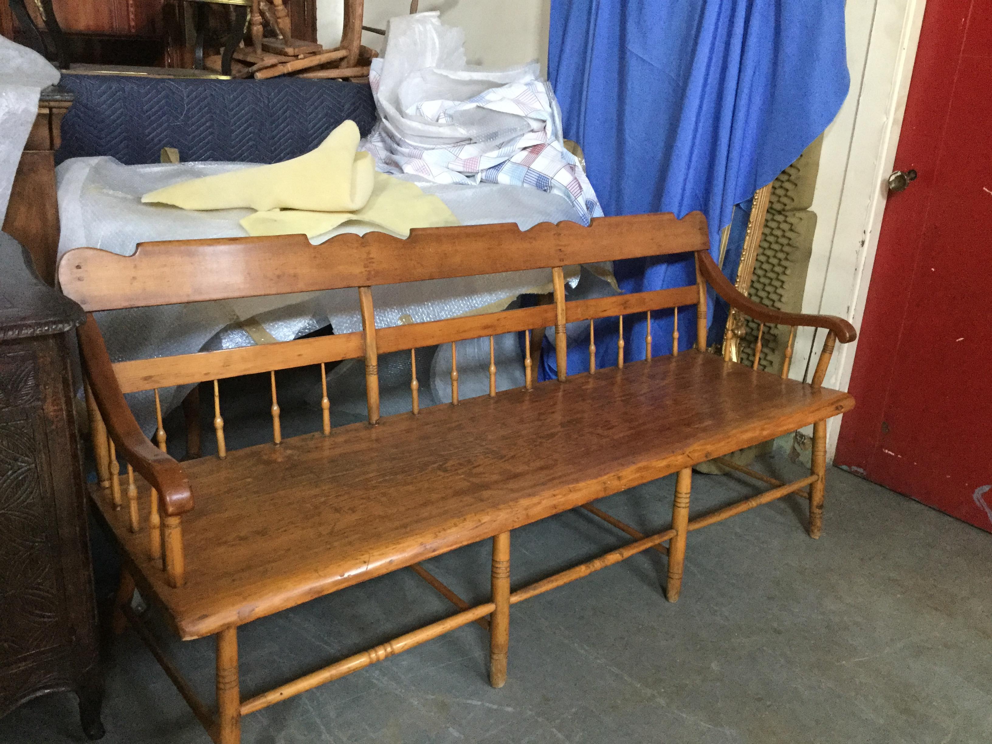 This is a true American antique bench. Made of solid maple, this bench dates from the early 1900’s. The seat is made from a solid plank of wood, and the spindles are both decorative and form the stability of the piece. This is a colonial style