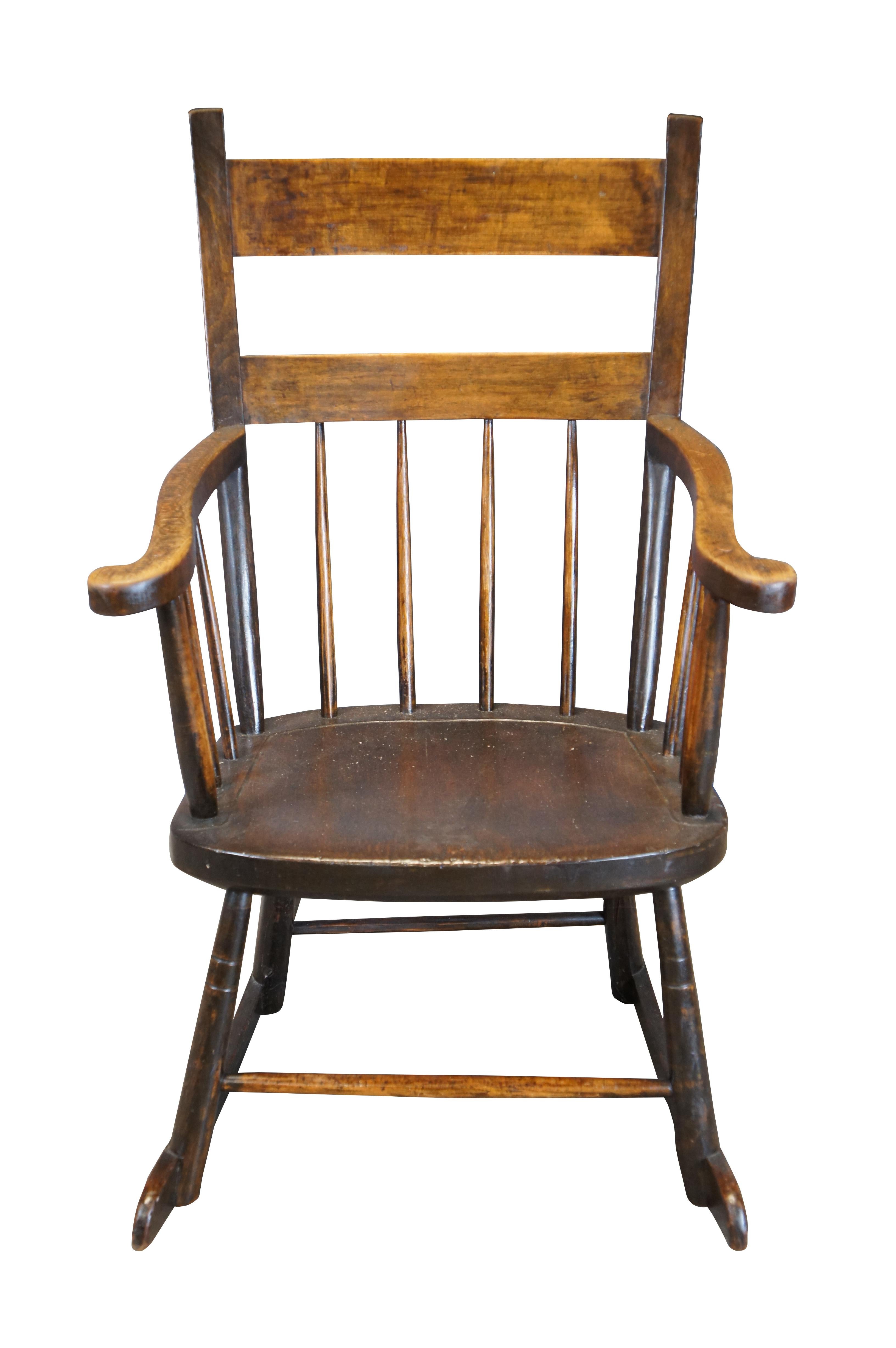 Early 20th Century American Country Farmhouse Rocking Chair. Made from oak with a ladder form, splindles and serpentine flared arms.

Dimensions:
29
