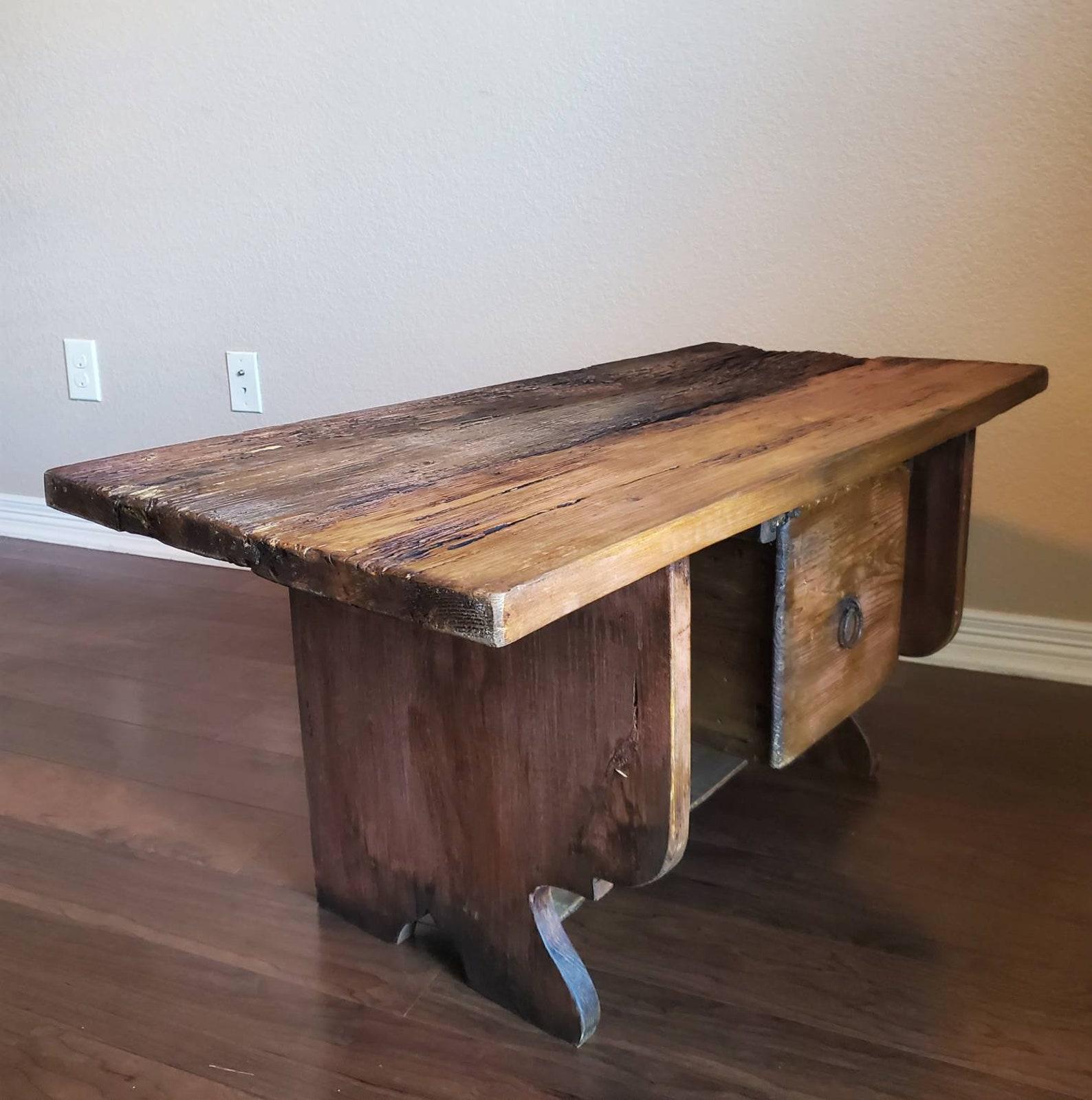 A rustic, primitive painted pine table / bench, with a live edge wood slap, loaded with interesting character, having rich antique wood color and tone, with outstanding warm, rustic patina throughout. A wonderful example of early American farm house