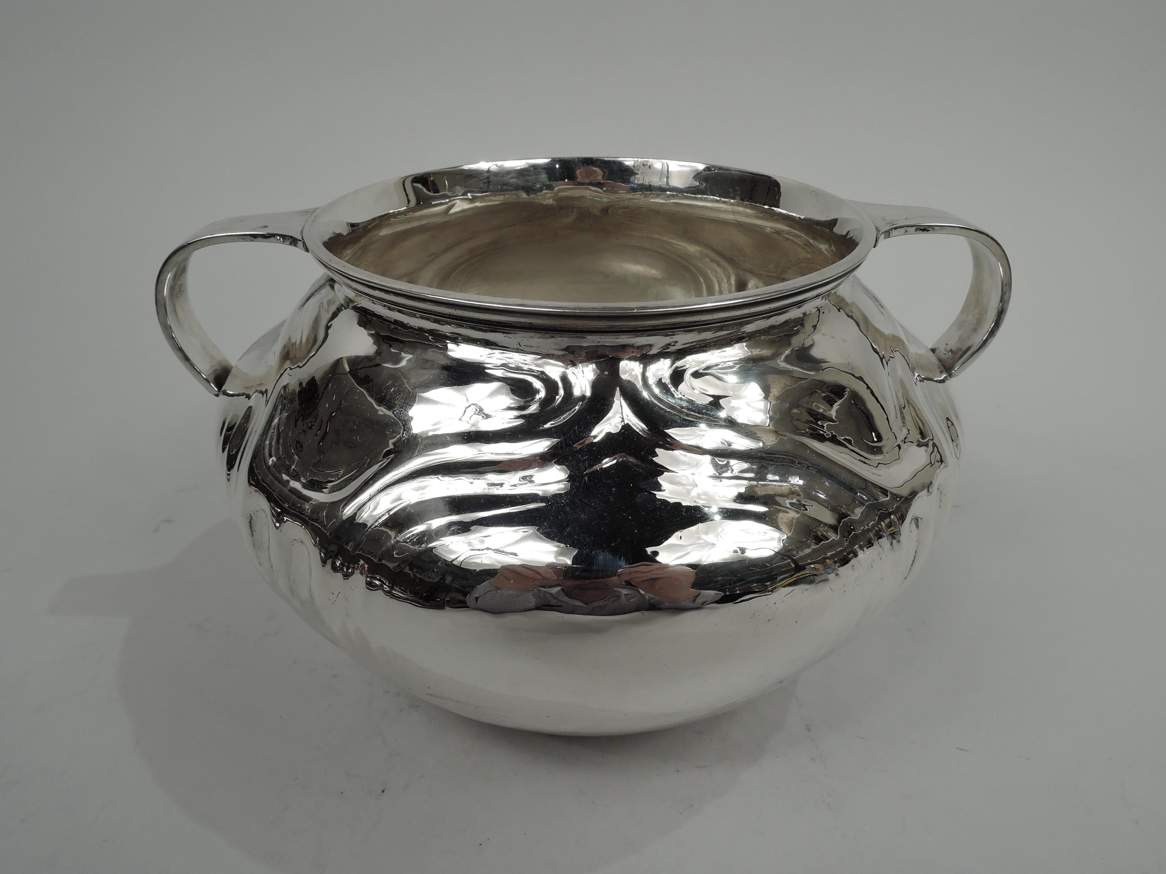 Craftsman sterling silver bowl. Made by Lebkuecher in Newark, circa 1920. Ovoid with reeded rim and small c-scroll handles. Fluting and ogee-form frames (vacant). A traditional pottery form with visible hand hammering. Fully marked including maker’s
