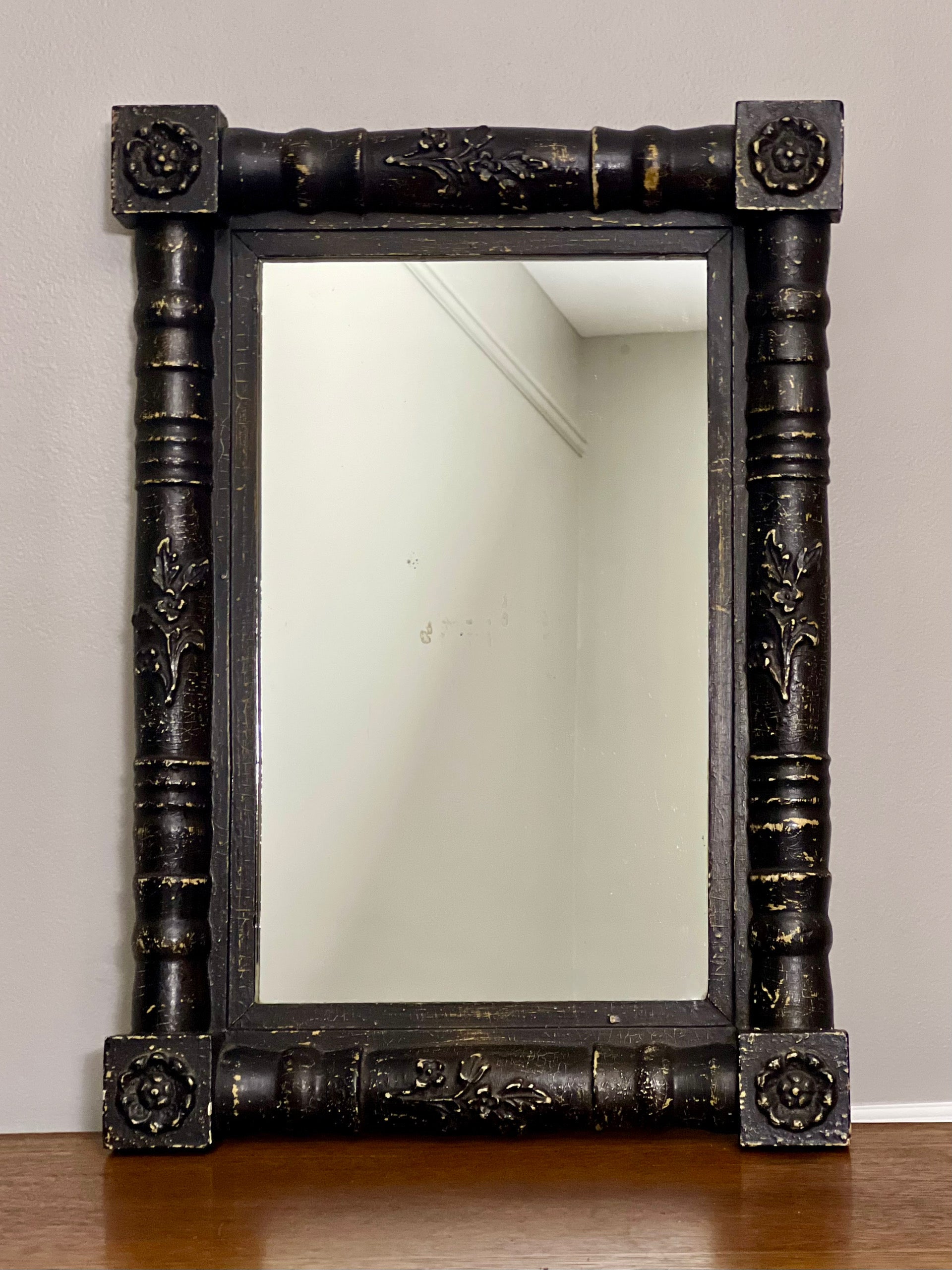 Antique American Eastlake style black painted rectangular wood mirror, circa 1870-1890. It is a fine example of the period combining low relief floral and geometric carvings along the frame's border. The heavy frame has a rounded edge with raised,