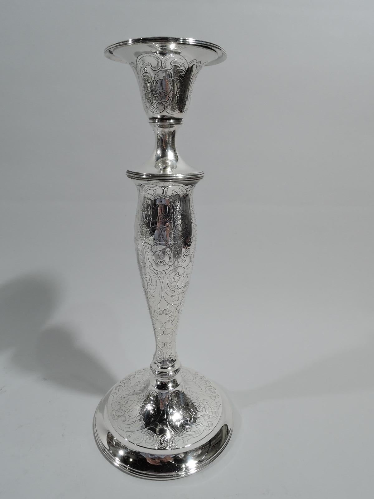 Pair of Edwardian Art Nouveau sterling silver candlesticks. Each: Tapering socket with detachable bobeche on ovoid shaft with reeded base knop on raised foot. Engraved ornament in form of soft and loose leaves and scrolls. Fully marked including