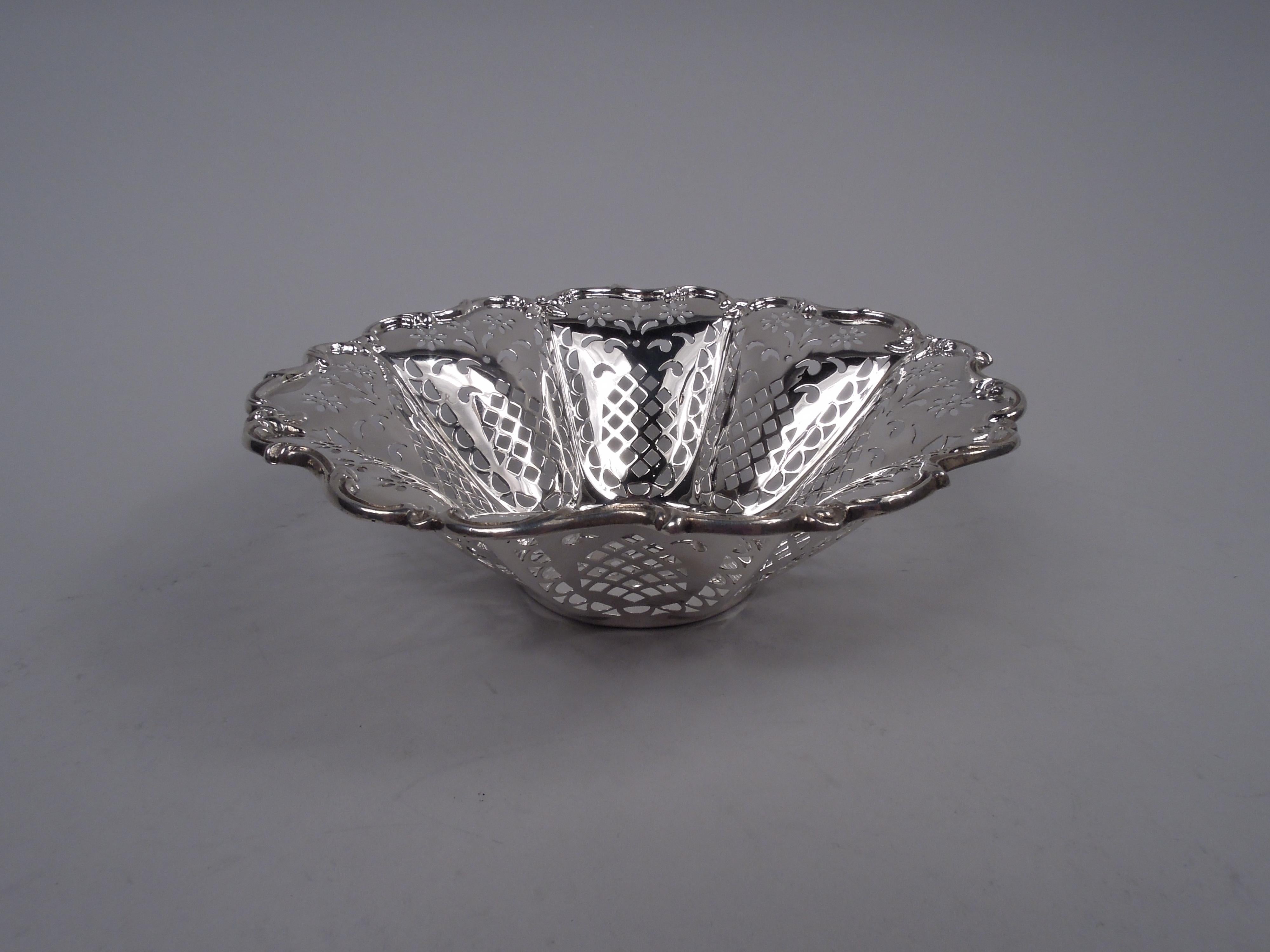 Ciotola classica americana edoardiana in argento, 1910 circa. Pozzo rotondo e solido con lati lobati e affusolati e bordo con volute e fiori applicati. Ornamento a forma di pannolino traforato, fiore e foglia. Completamente marcato con il timbro del
