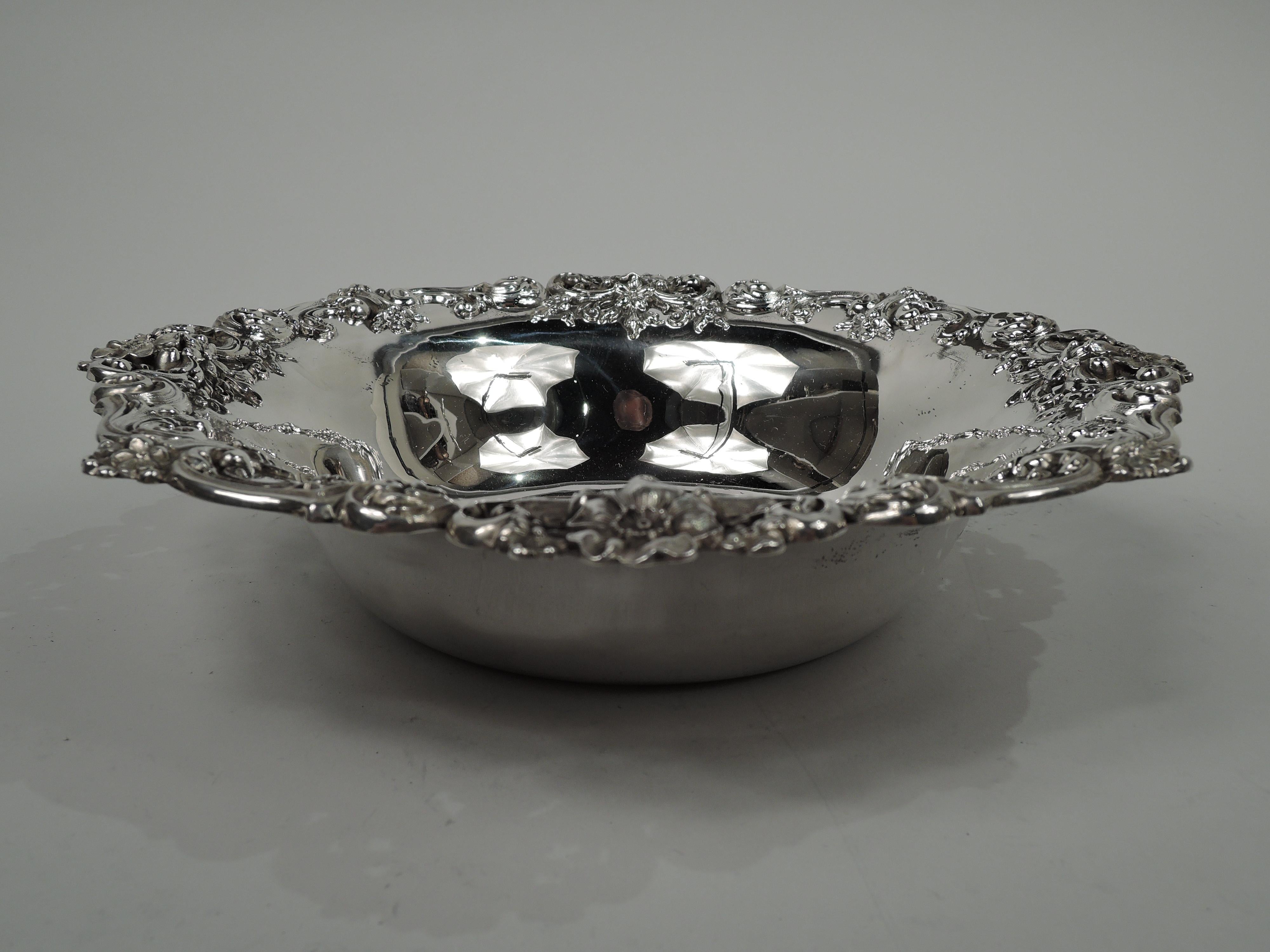 Edwardian Classical sterling silver bowl. Made by Redlich & Co. in New York, circa 1900. Tapering sides and flared rim; applied and pierced rim with cast leafing scrolls and flowers. Fully marked including maker’s and retailer’s (Cowell & Hubbard)
