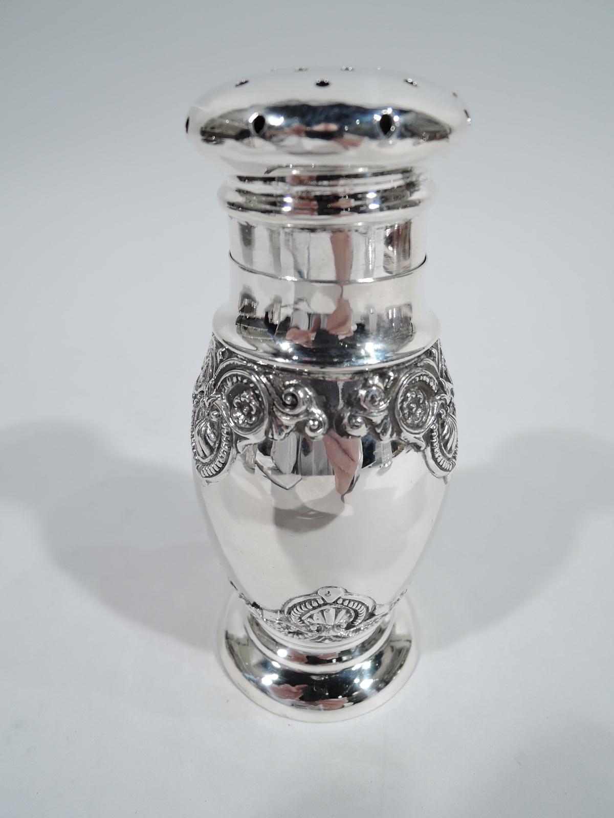 American classical sterling silver sugar shaker, ca 1910. Ovoid body on round and raised foot. Pierced and overhanging cover. Applied scallop shells and flower heads in gadrooned and leafing frames. Marked “Sterling”. Weight: 4.5 troy ounces.