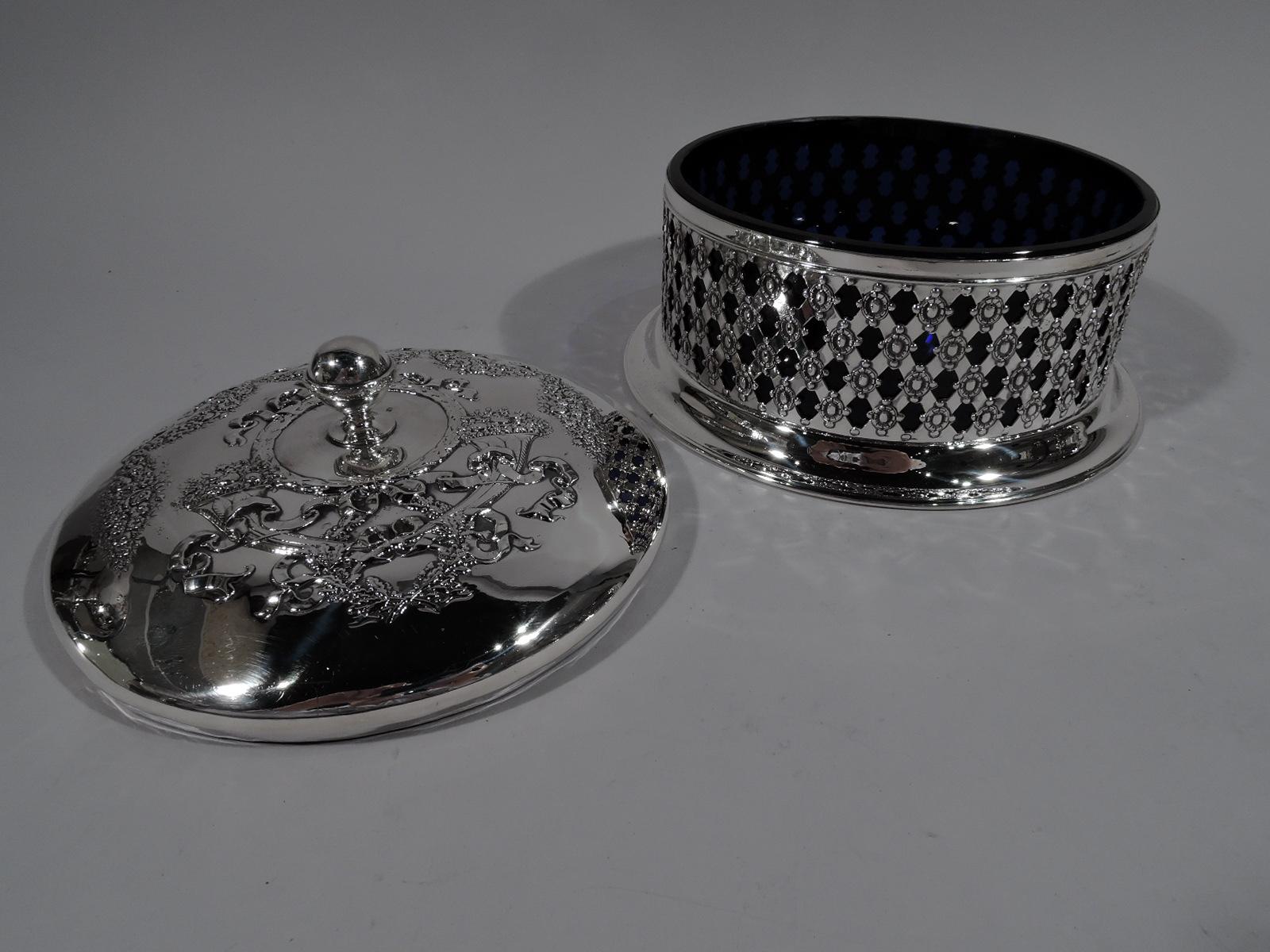 Turn-of-the-century American Edwardian sterling silver box. Retailed by Black, Starr & Frost in New York. Round with plain and solid spread foot. Sides open basket-weave with beaded flower heads. Cover gently raised with ball finial chased ornament