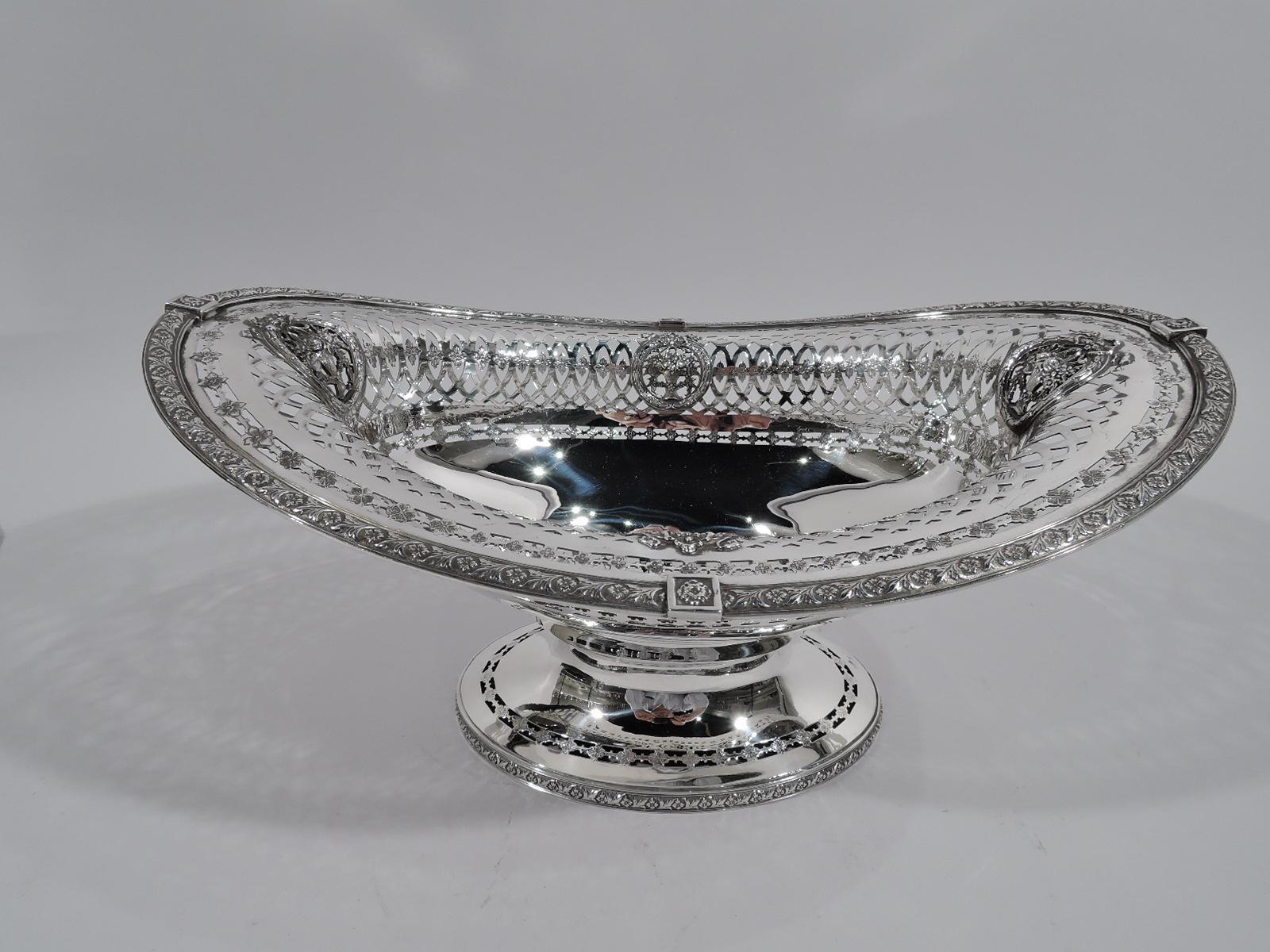 American Edwardian sterling silver bowl, circa 1900. Boat-form oval with solid well. Sides have pierced and interlaced ovals inset with blossoms, and rondels inset with flower baskets. Raised oval foot. Pierced blossom borders and chased