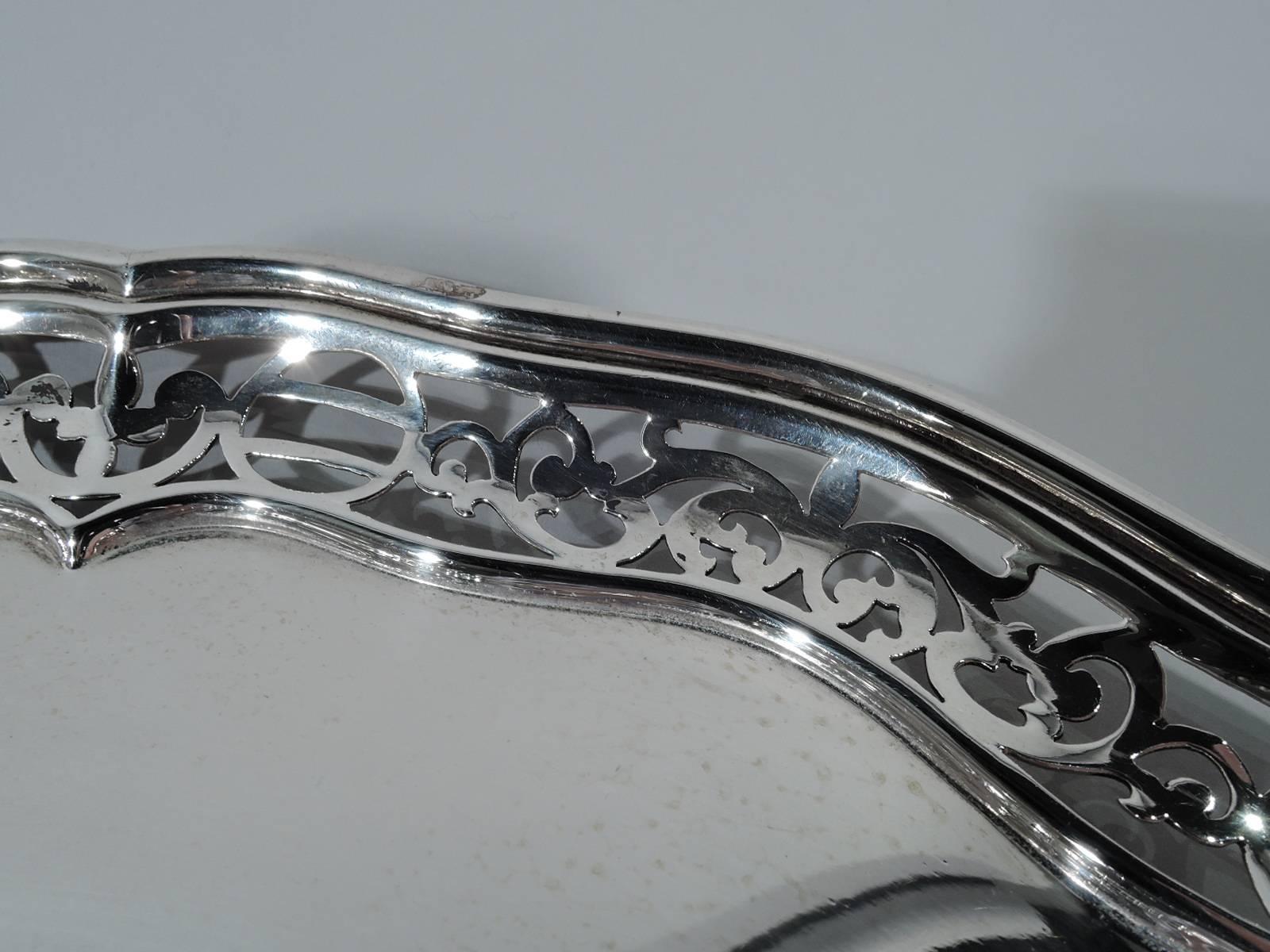 Edwardian sterling silver tray. Made by Theodore B. Starr in New York. Shaped circle with solid well and molded rim. Sides tapering with scrolled and geometric piercing. Hallmark includes no. 1224. Weight: 17.8 troy ounces.