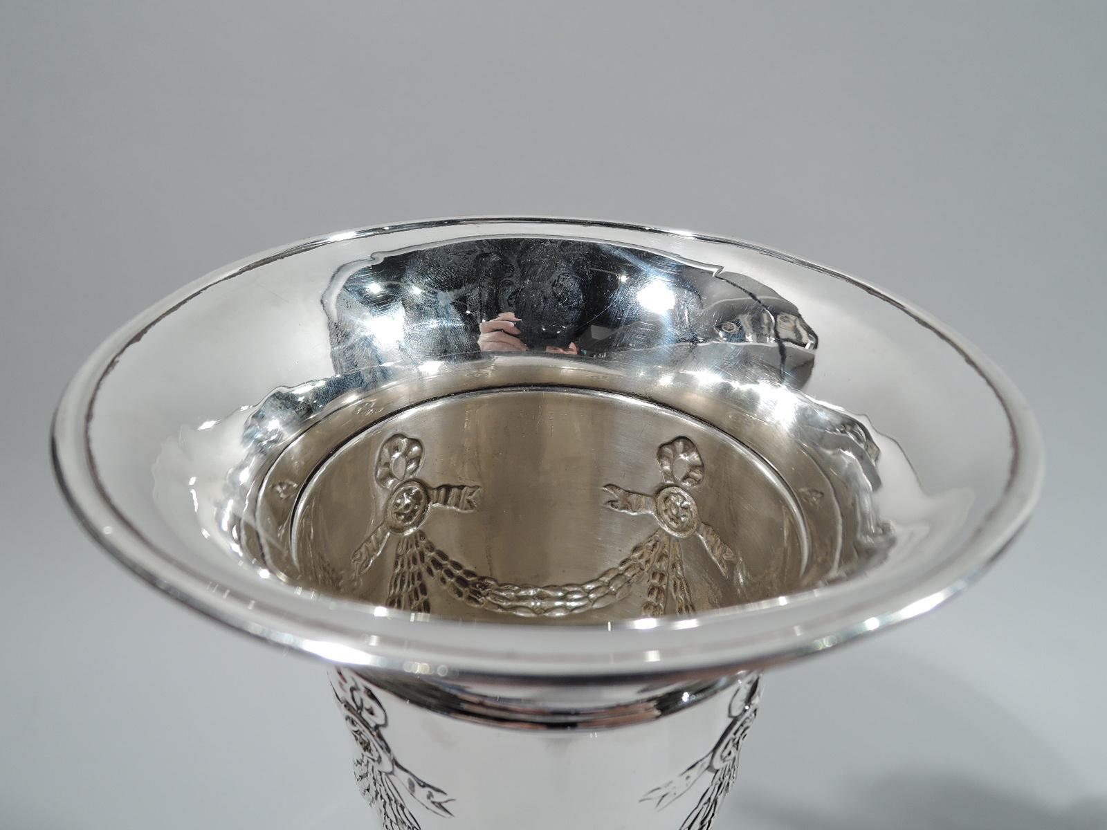 Edwardian Regency sterling silver vase. Made by Black, Starr & Frost in New York, ca 1910. Straight and tapering sides with flared rim and spread foot. Chased ornament with ribboned garland at top and acanthus and fluted border at base. Fully marked