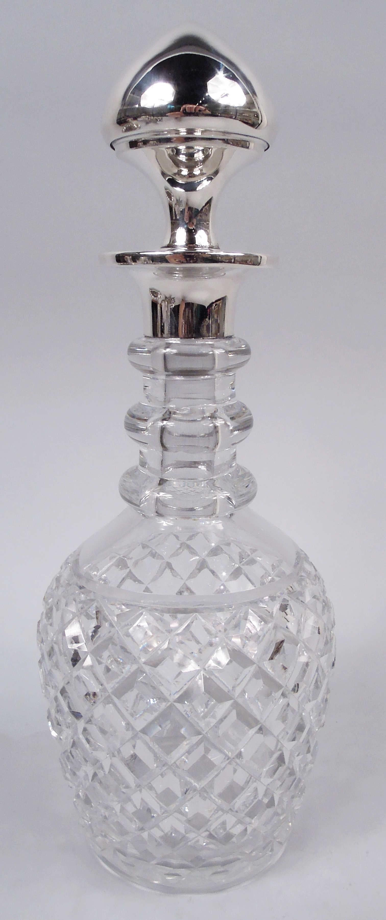 American Edwardian glass decanter with sterling silver mounts, ca 1910. Ovoid bowl with raised diaper; cylindrical neck with 3 rings; neck inset with sterling silver collar and wide mouth rim. Conical stopper same. Stopper and neck marked