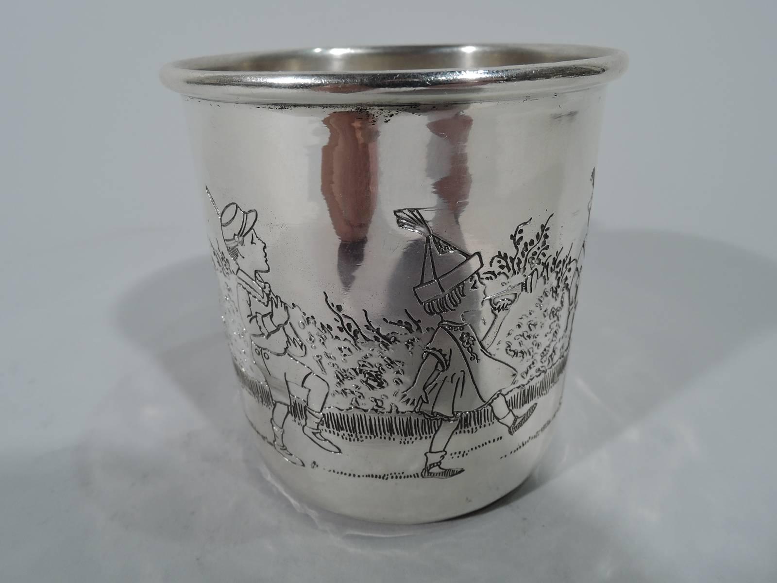 Edwardian sterling silver baby cup. Made by HR Morss in Attleboro, Mass. Straight sides, molded rim, and c-scroll handle. Etched procession of boys and girls drumming, trumpeting, sword waving, and flag flying. A sweet piece with patriotic and