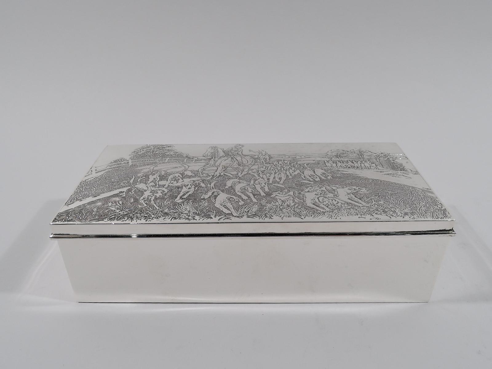 Edwardian sterling silver box. Made by McChesney in New York, circa 1920. Rectangular with straight sides. Cover hinged with wraparound flat rim. On cover is acid-etched fox hunt scene: A rider looks around with the pack on the scent; a second rider