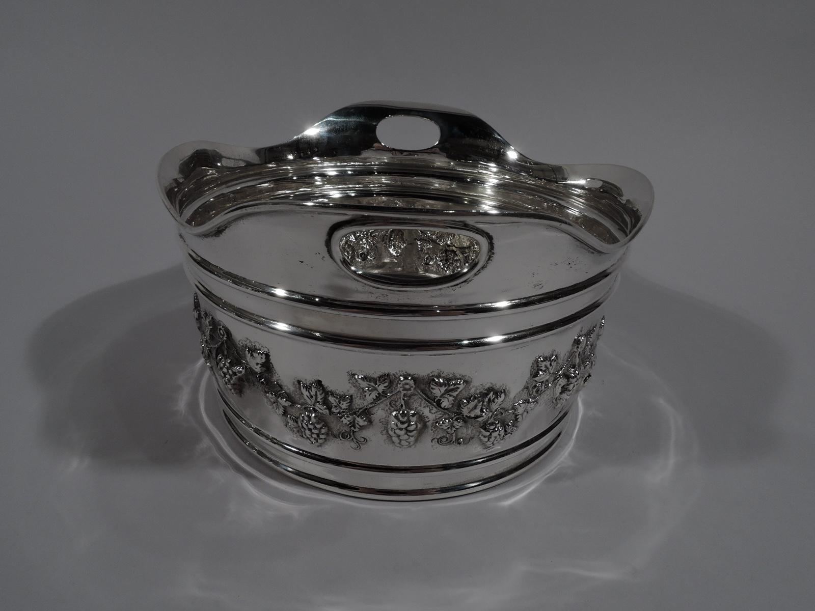 Turn-of-the-century Edwardian sterling silver ice bucket. Made by Duhme in Cincinnati, circa 1910. Round with wavy rim and cut out oval handles. Chased fruiting grapevine between barrel-like hoops. Bottom has raised concentric circles. Fully marked
