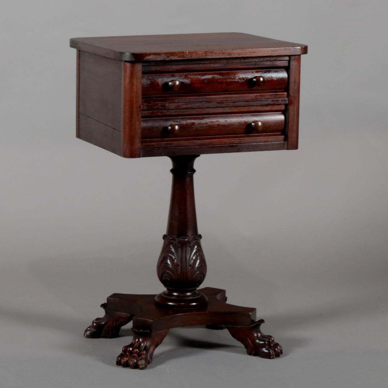 An antique American Empire side stand features mahogany construction with case having two convex drawers surmounting turned and acanthus carved column raised on base with carved paw feet, circa 1870

Measures: 28.5