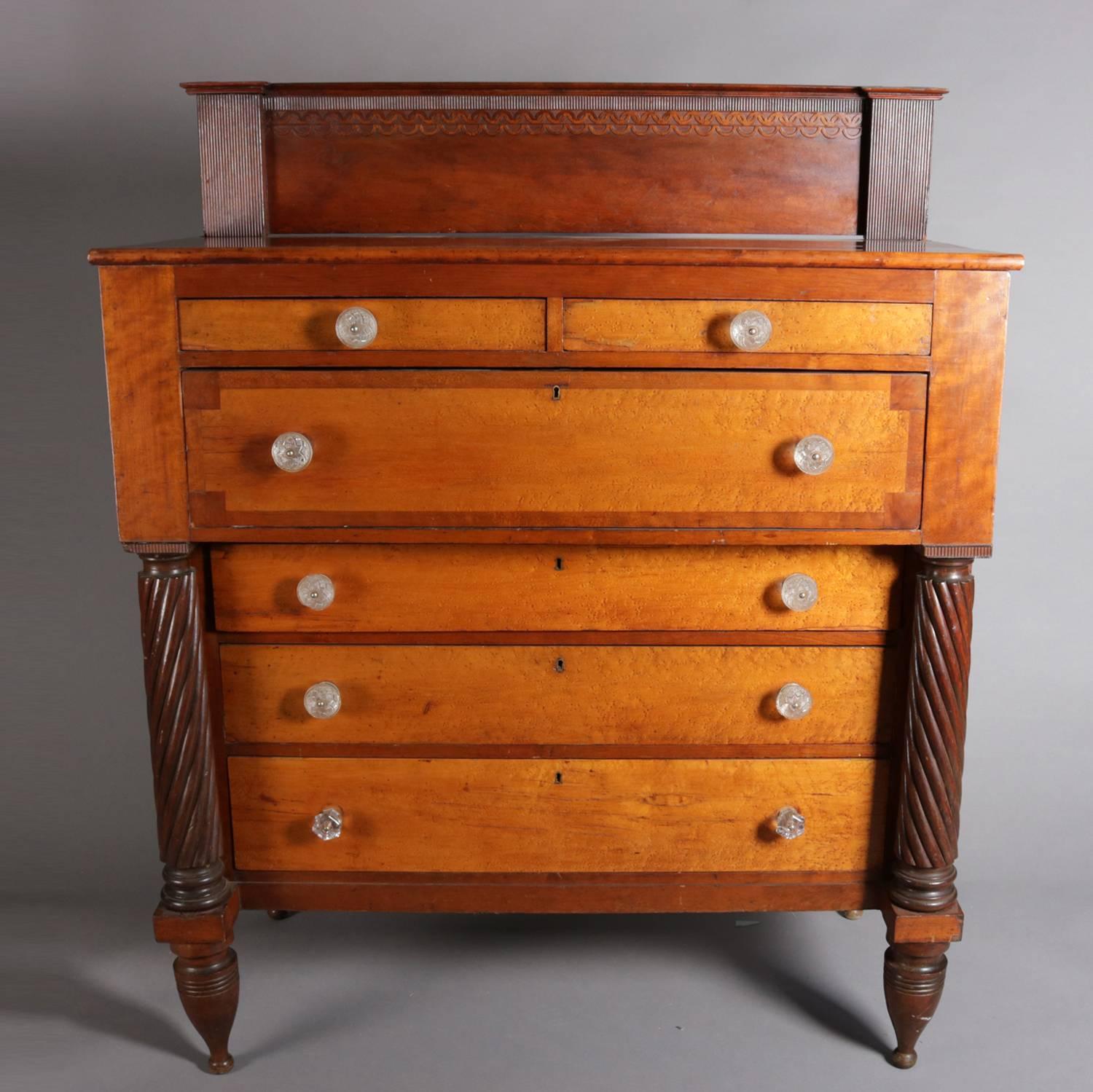 Antique American Empire chest of drawers features cherry case with two smaller drawers over four long drawers, all faced in bird's-eye maple and having sandwich glass pulls, case with decorated backsplash, flanking rope twist columns and seated on