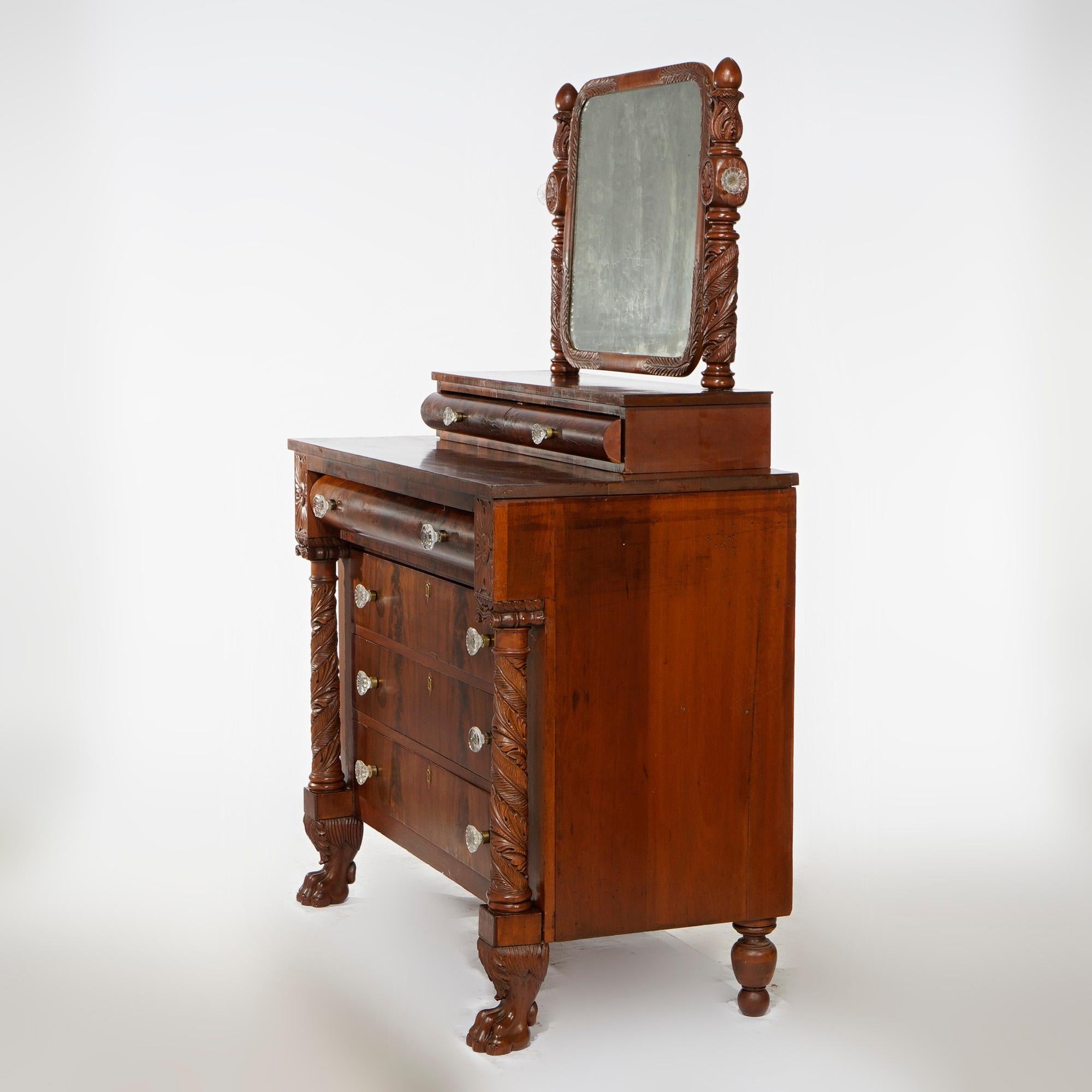 An antique American Empire chest of drawers with swivel mirror over flame mahogany chest of drawers with deeply foliate carved flanking columns and paw feet, c1840

Measures- 65'' H x 44'' W x 23.75'' D.