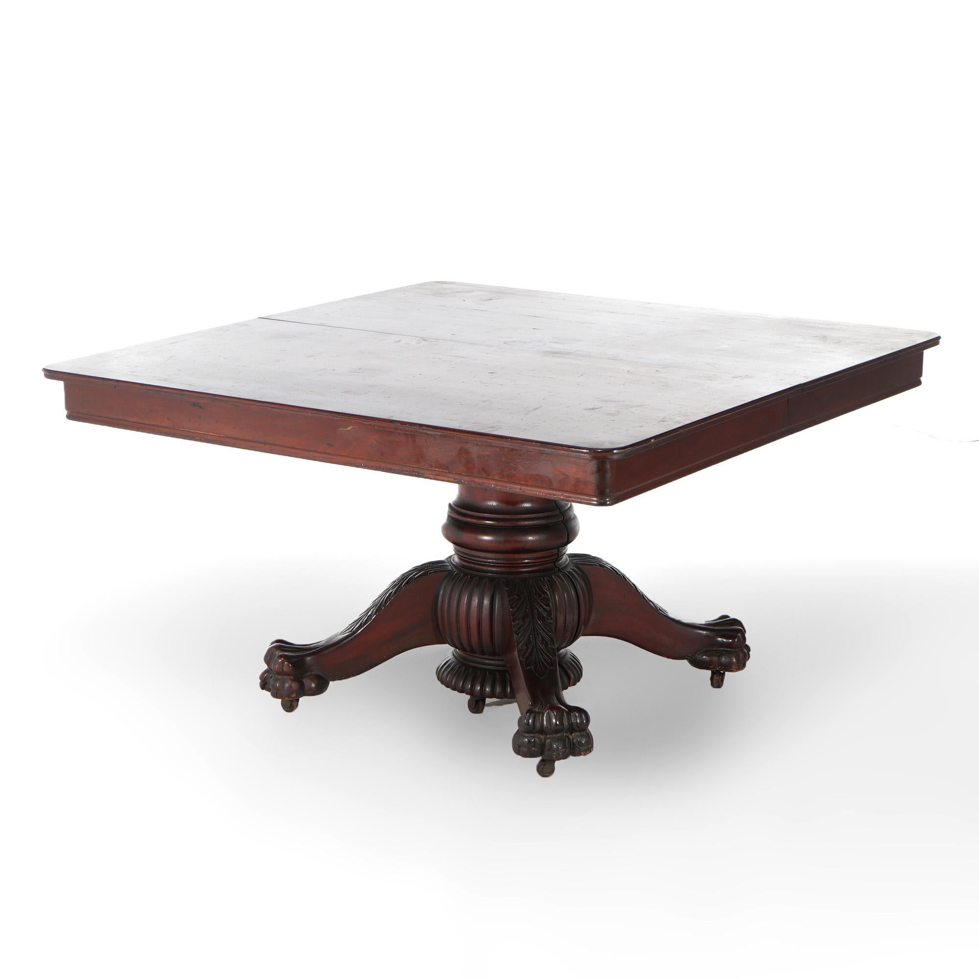 An antique American Empire extension banquet table offers mahogany construction with central split urn form pedestal with four legs terminating in carved paw feet; square table extends to accept up to six leaves; c1880
Carved Mahogany Banquet Table
