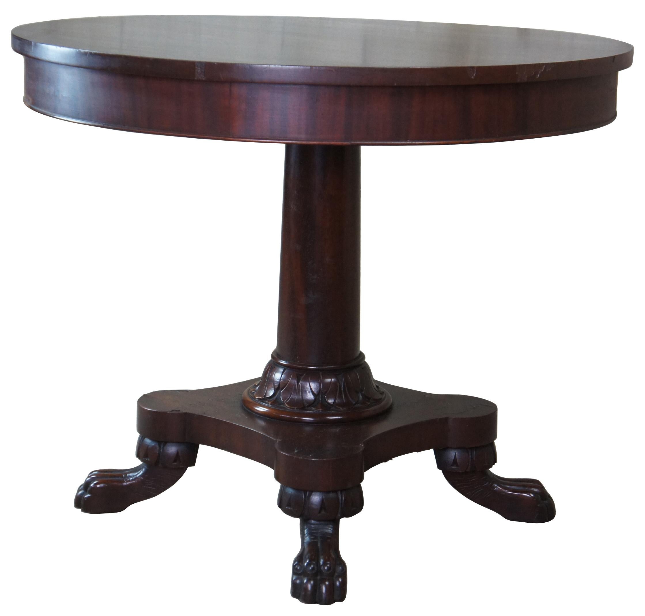 Victorian era center or side table from the last half of the 19th century. A round form made from solid mahogany. Features a turned and graduated center post leading to an acanthus carved capital over lion paw foot carved base.
        