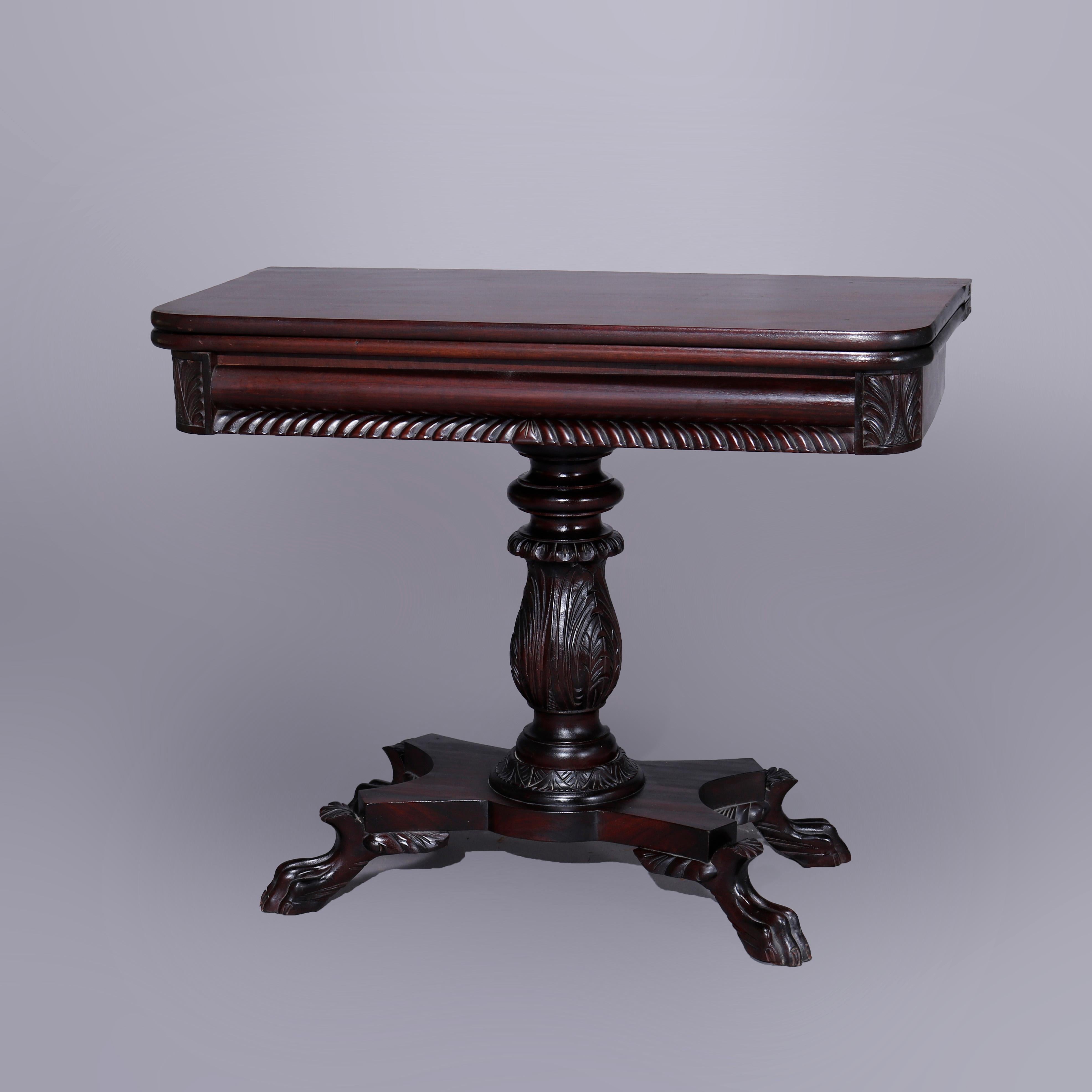 An antique American Empire classical card table offers mahogany construction with flip top surmounting garoon and acanthus carved skirt, raised on acanthus balustrade column with base having paw feet, c1840.

Measures- 25.25''H x folded 17.25''W x