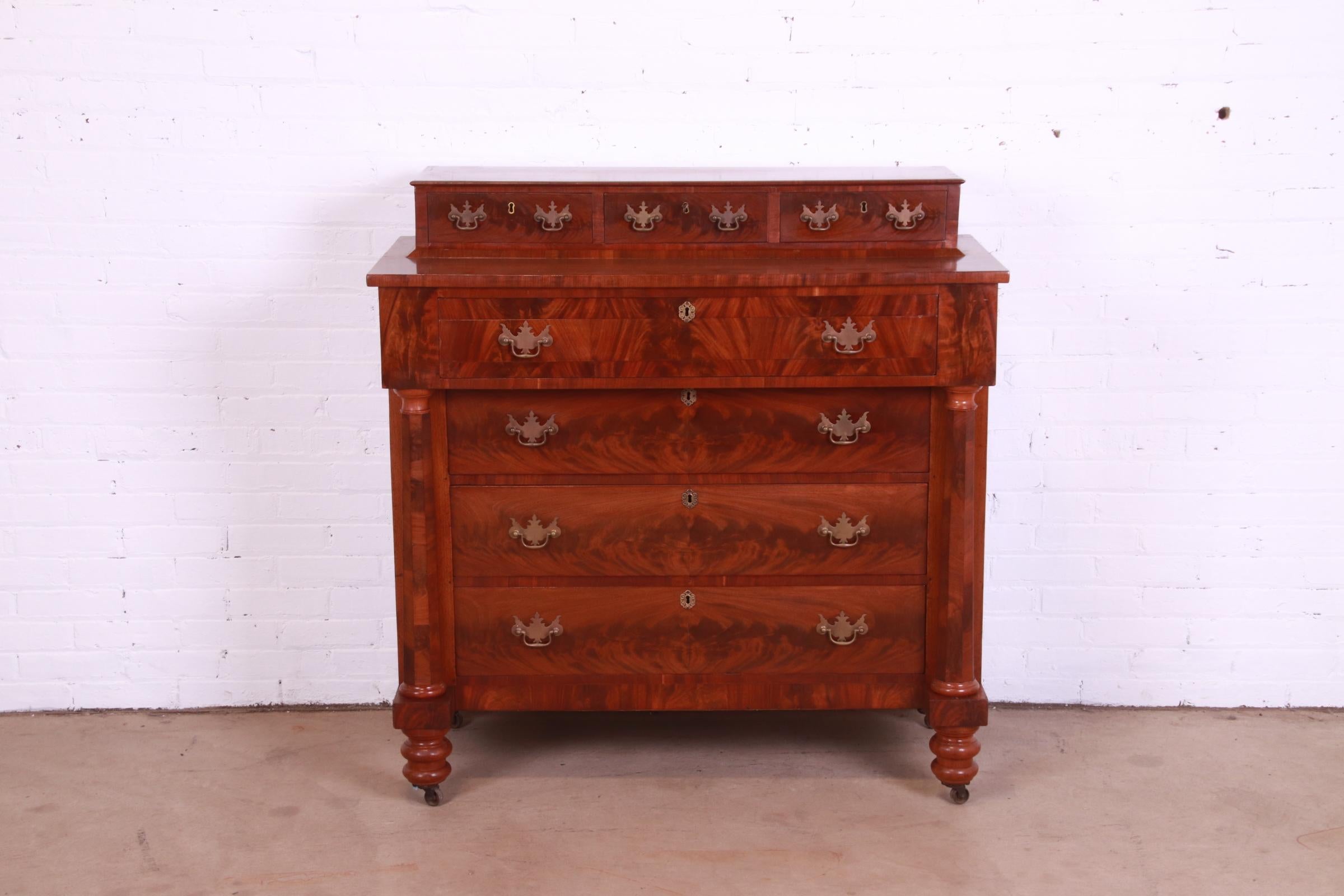 A gorgeous antique American Empire seven-drawer dresser or chest of drawers

USA, Circa 1850s

Stunning book-matched flame mahogany, with brass hardware.

Measures: 45